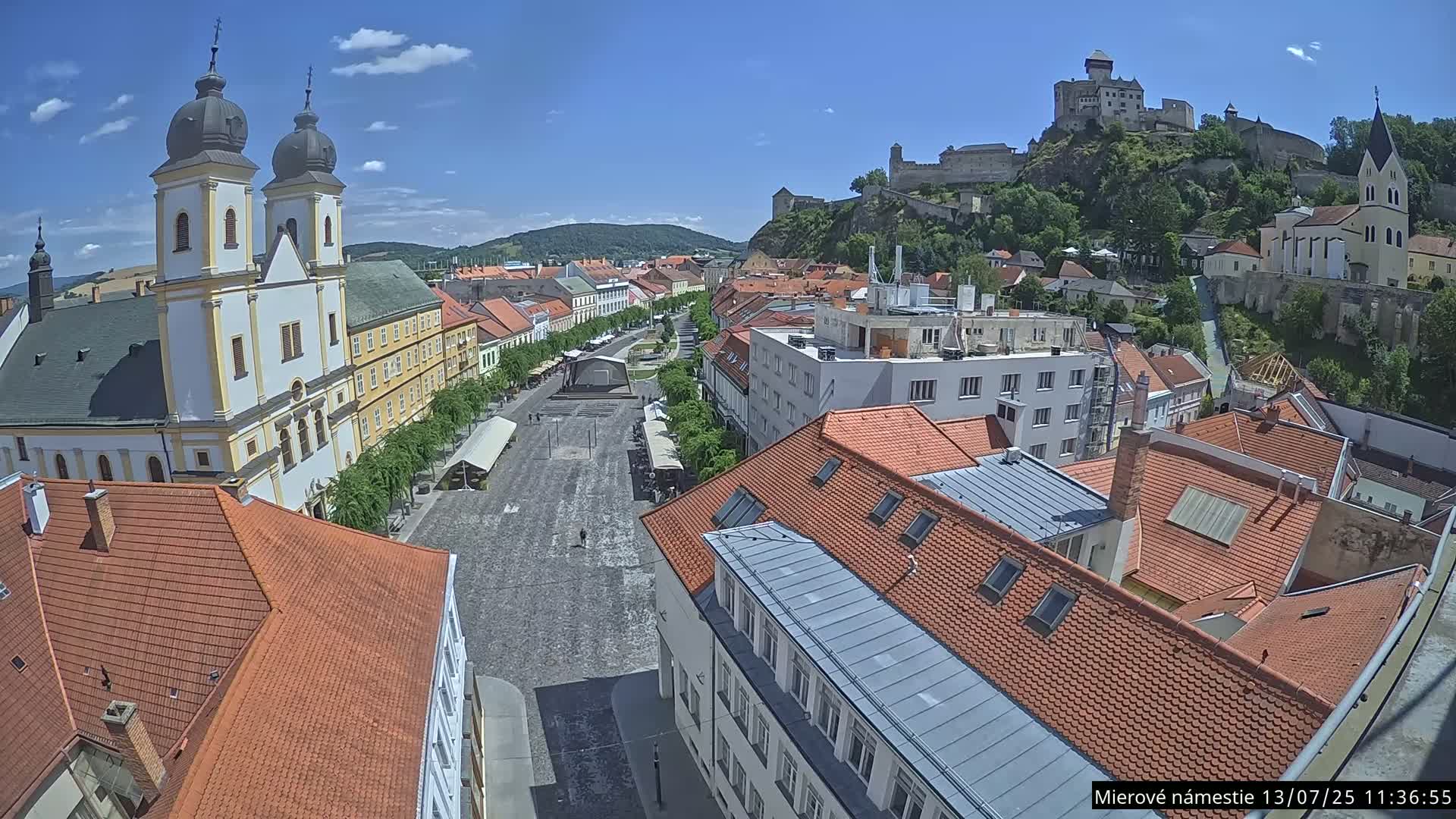Trenčín, Piaristický kostol sv. Františka Xaverského Church & Trenciansky Hrad (Ttencin Castle) at Mierové námestie Square East View Live Cam - Trencin, Okres Trencin, Slovakia 