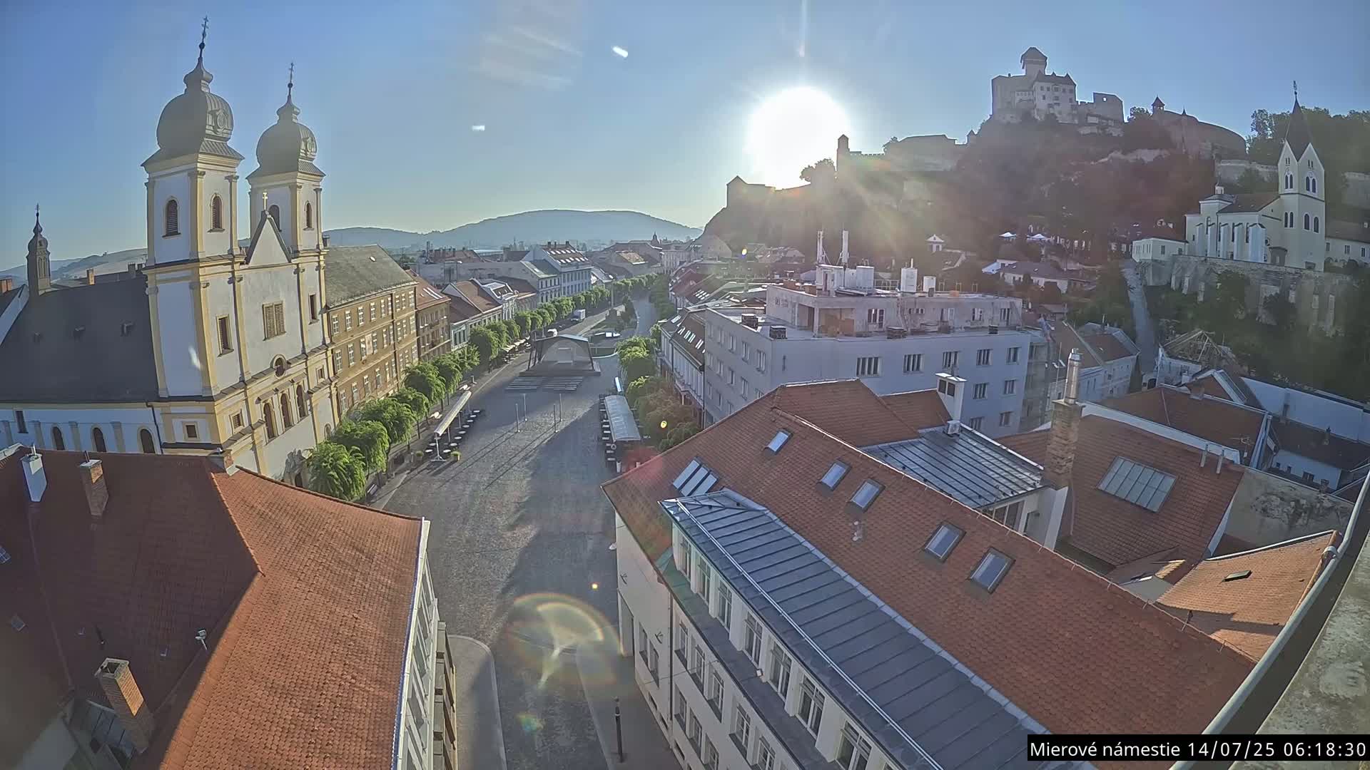 Trenčín, Piaristický kostol sv. Františka Xaverského Church & Trenciansky Hrad (Ttencin Castle) at Mierové námestie Square East View Live Cam - Trencin, Okres Trencin, Slovakia 