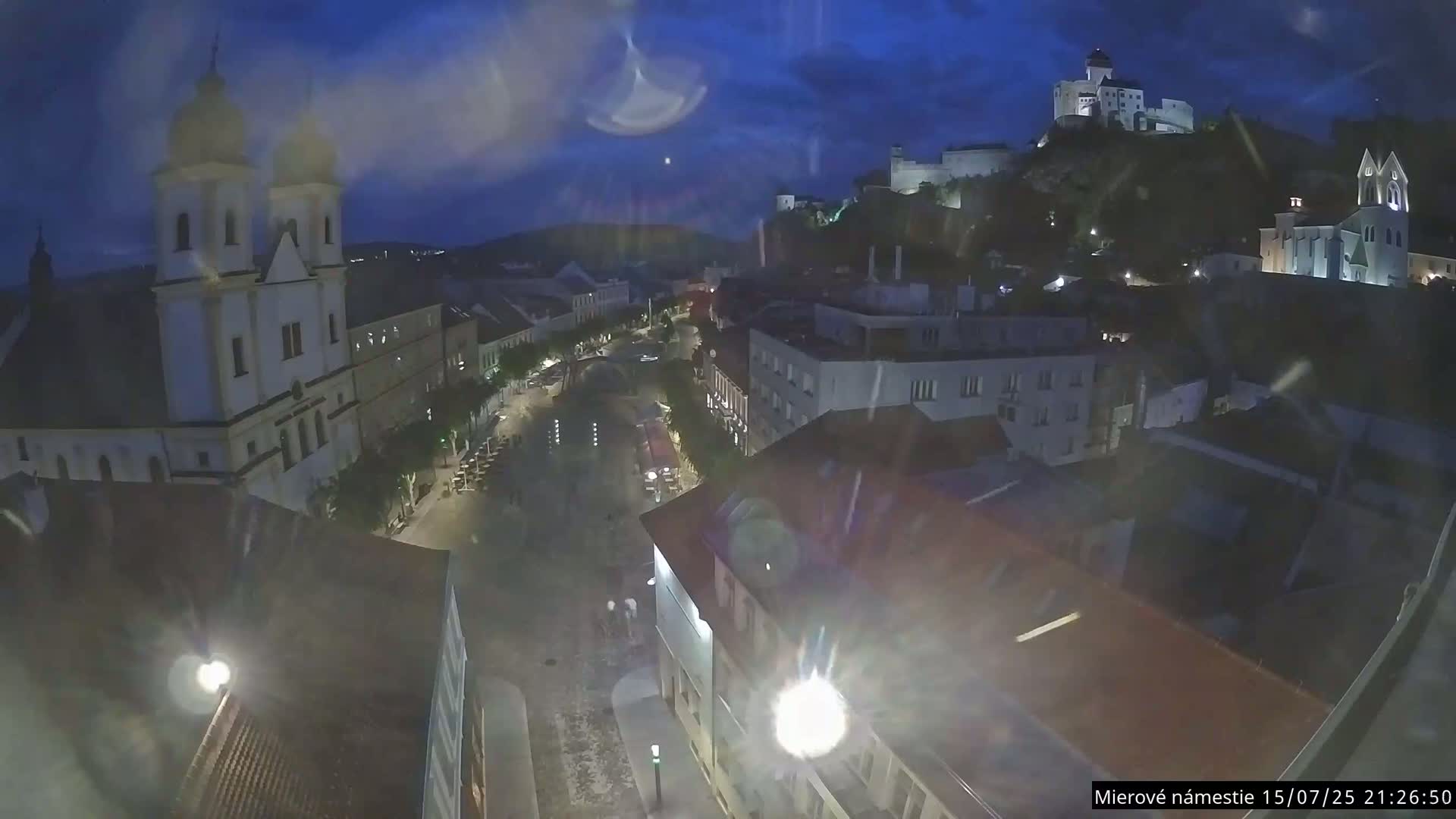 Trenčín, Piaristický kostol sv. Františka Xaverského Church & Trenciansky Hrad (Ttencin Castle) at Mierové námestie Square East View Live Cam - Trencin, Okres Trencin, Slovakia 