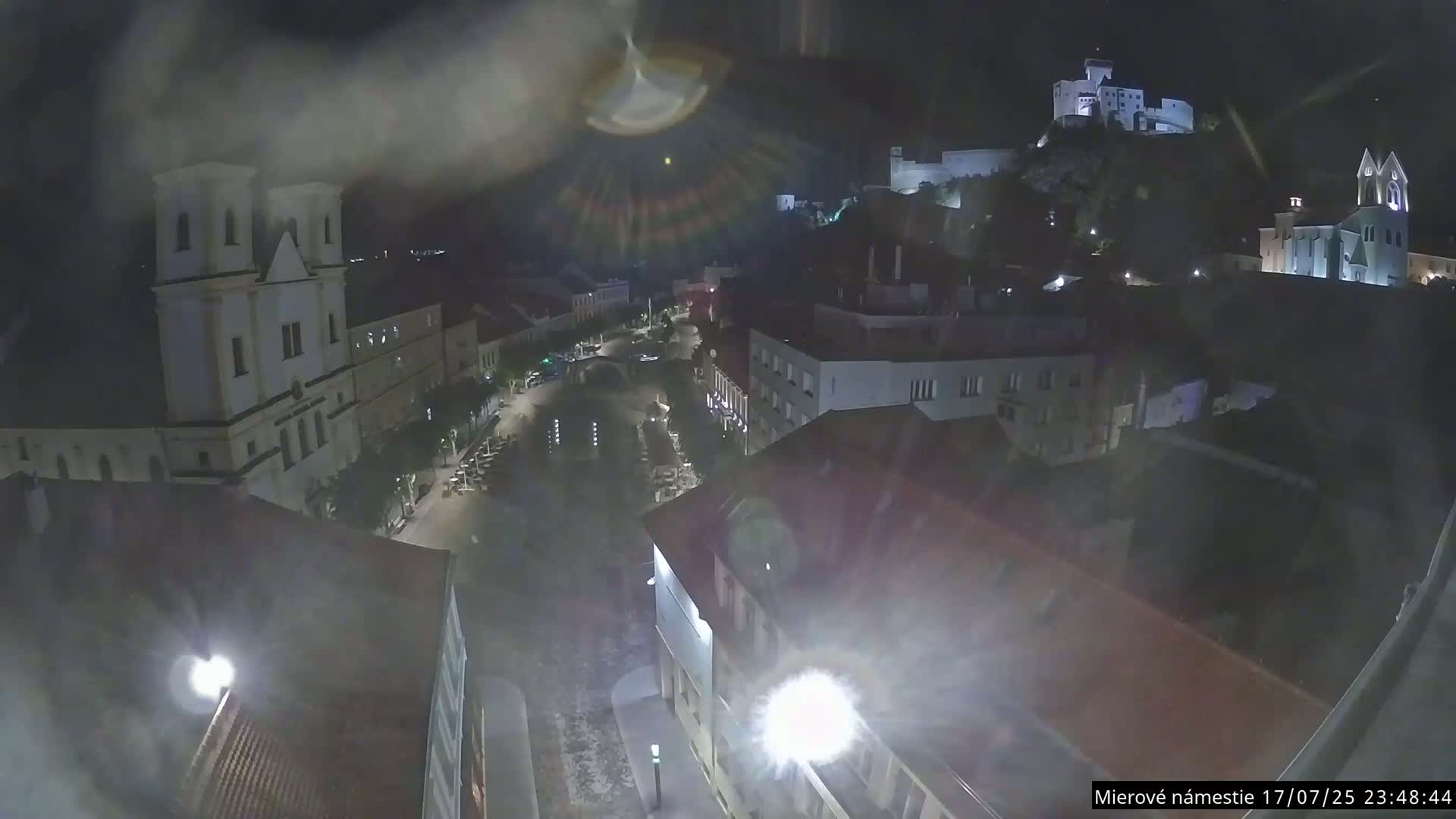 Trenčín, Piaristický kostol sv. Františka Xaverského Church & Trenciansky Hrad (Ttencin Castle) at Mierové námestie Square East View Live Cam - Trencin, Okres Trencin, Slovakia 