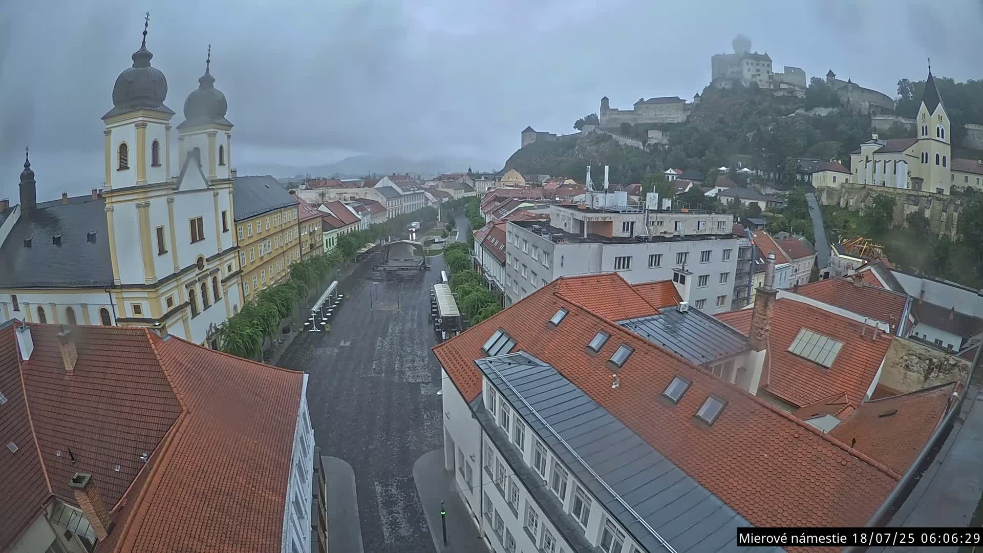 Trenčín, Piaristický kostol sv. Františka Xaverského Church & Trenciansky Hrad (Ttencin Castle) at Mierové námestie Square East View Live Cam - Trencin, Okres Trencin, Slovakia 