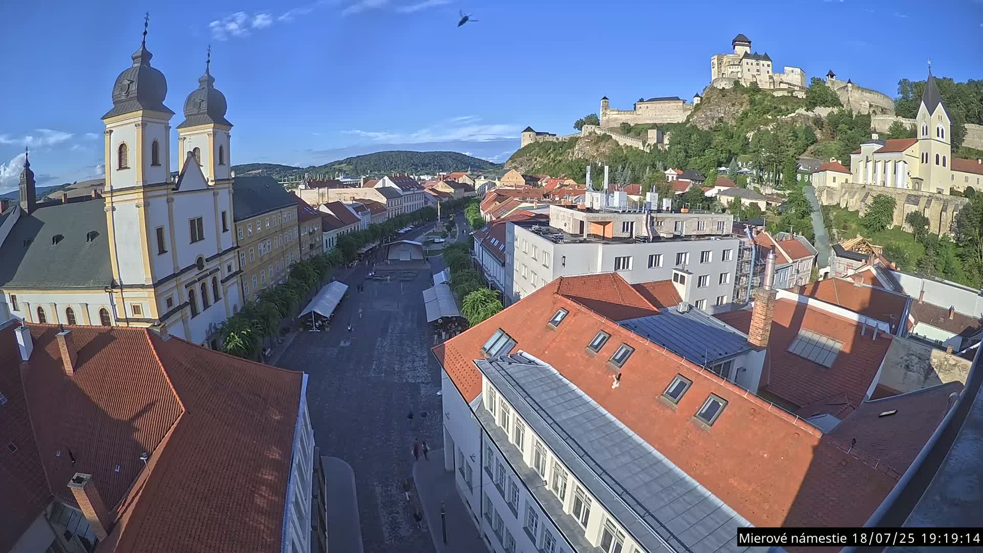 Trenčín, Piaristický kostol sv. Františka Xaverského Church & Trenciansky Hrad (Ttencin Castle) at Mierové námestie Square East View Live Cam - Trencin, Okres Trencin, Slovakia 
