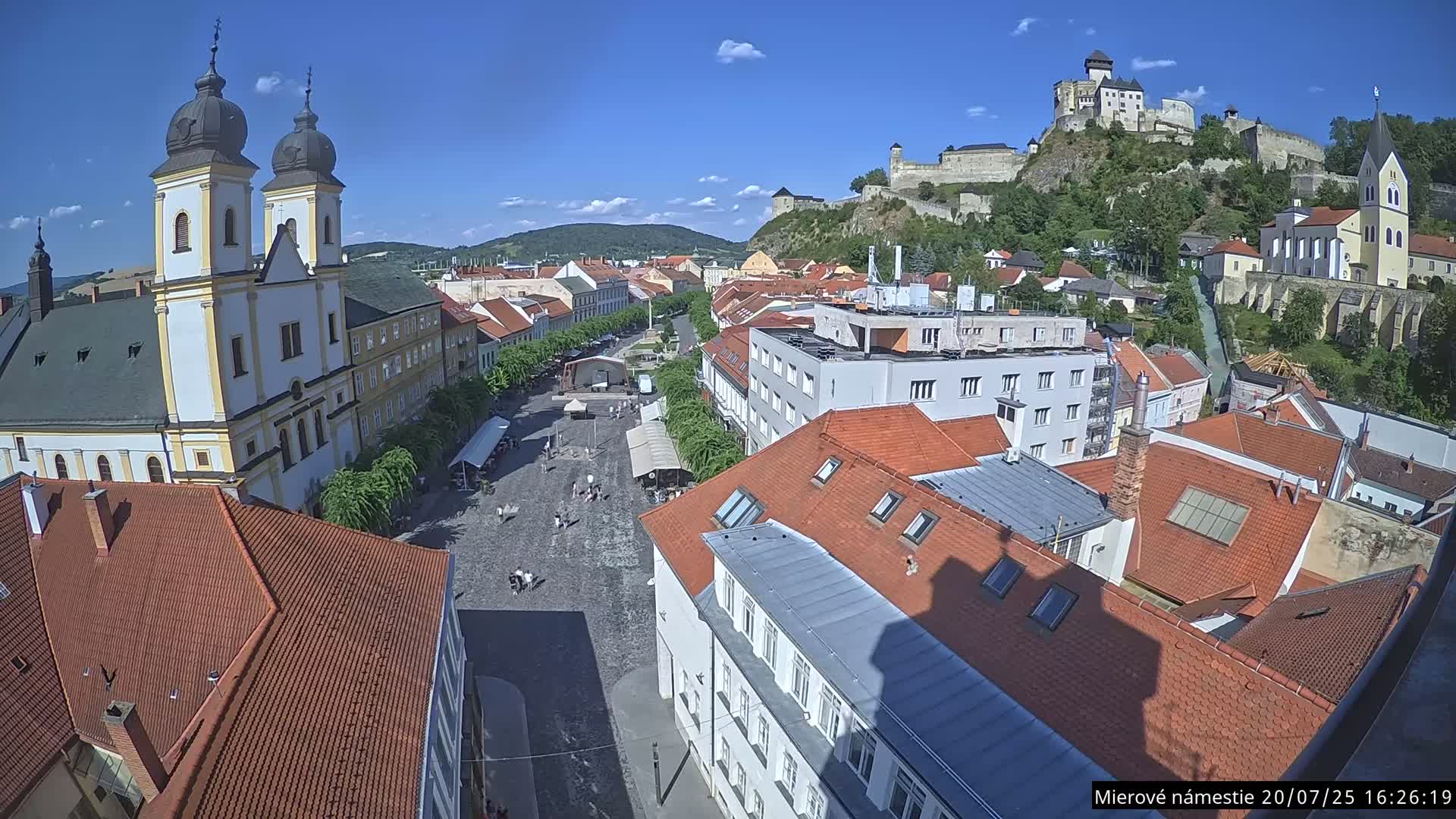 Trenčín, Piaristický kostol sv. Františka Xaverského Church & Trenciansky Hrad (Ttencin Castle) at Mierové námestie Square East View Live Cam - Trencin, Okres Trencin, Slovakia 