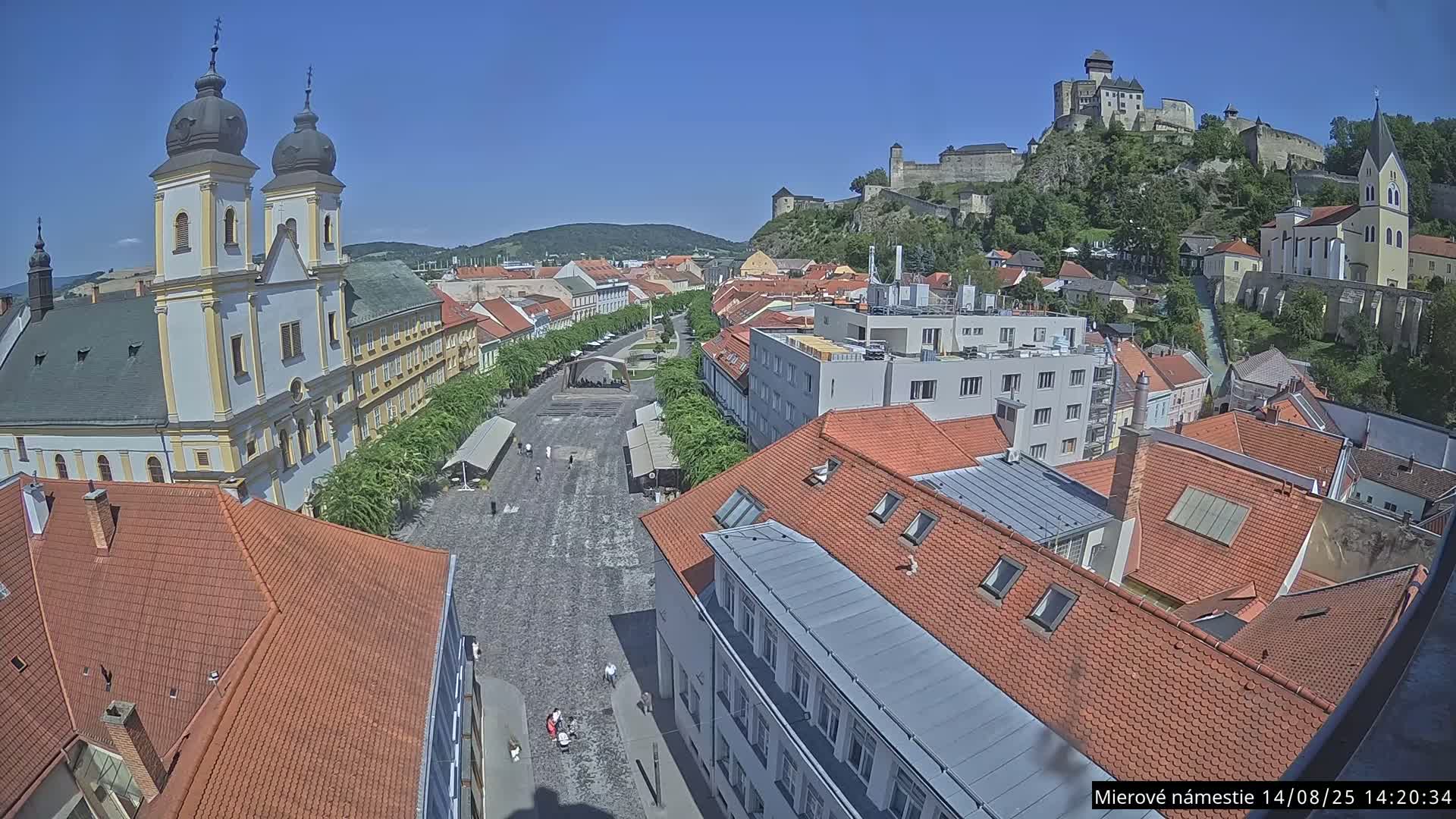 Trenčín, Piaristický kostol sv. Františka Xaverského Church & Trenciansky Hrad (Ttencin Castle) at Mierové námestie Square East View Live Cam - Trencin, Okres Trencin, Slovakia 
