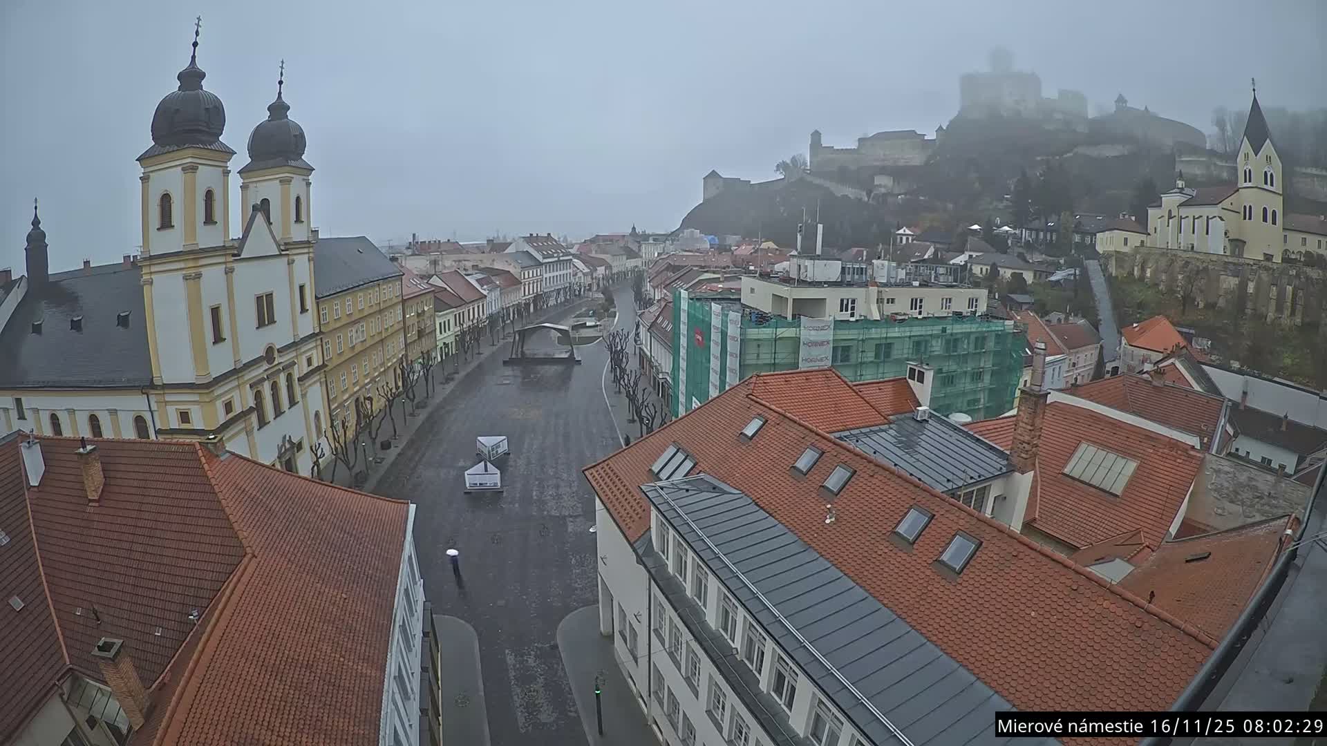 Trenčín, Piaristický kostol sv. Františka Xaverského Church & Trenciansky Hrad (Ttencin Castle) at Mierové námestie Square East View Live Cam - Trencin, Okres Trencin, Slovakia 