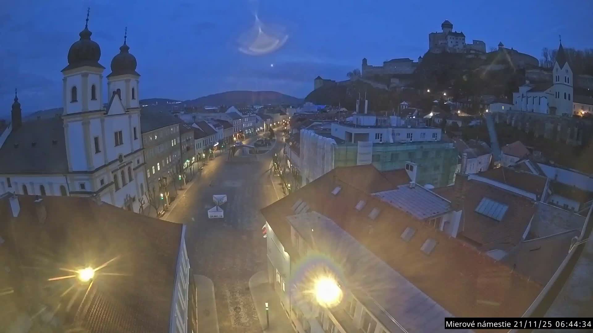 Trenčín, Piaristický kostol sv. Františka Xaverského Church & Trenciansky Hrad (Ttencin Castle) at Mierové námestie Square East View Live Cam - Trencin, Okres Trencin, Slovakia 