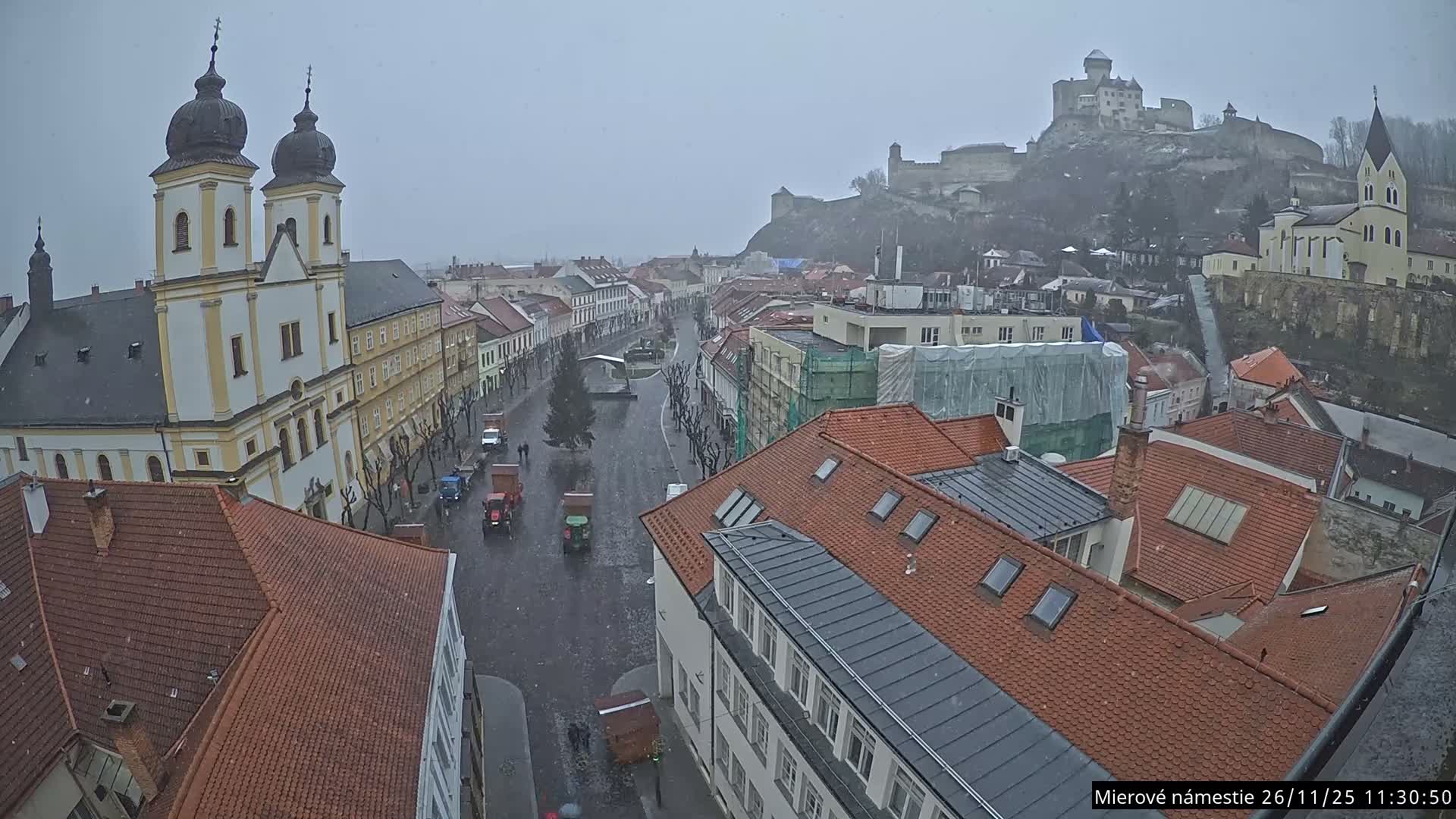 Trenčín, Piaristický kostol sv. Františka Xaverského Church & Trenciansky Hrad (Ttencin Castle) at Mierové námestie Square East View Live Cam - Trencin, Okres Trencin, Slovakia 