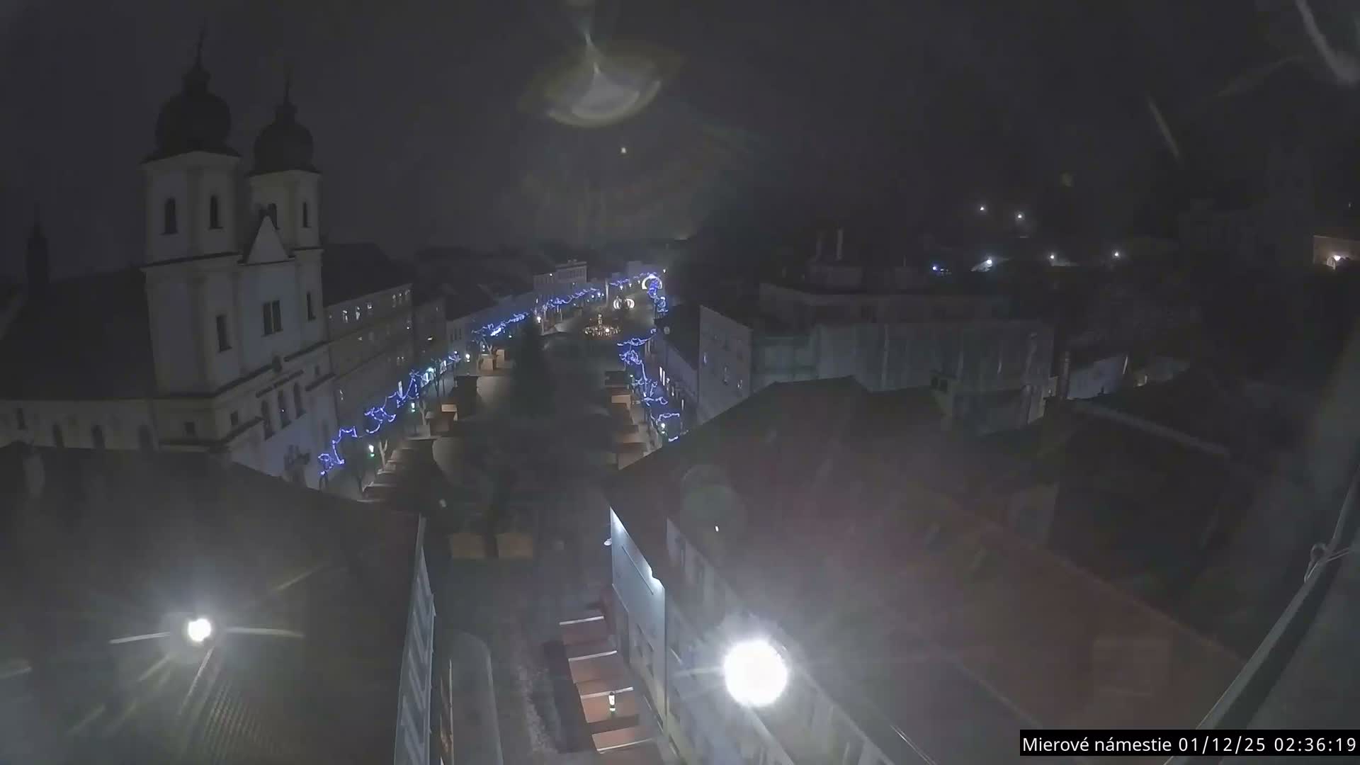 Trenčín, Piaristický kostol sv. Františka Xaverského Church & Trenciansky Hrad (Ttencin Castle) at Mierové námestie Square East View Live Cam - Trencin, Okres Trencin, Slovakia 