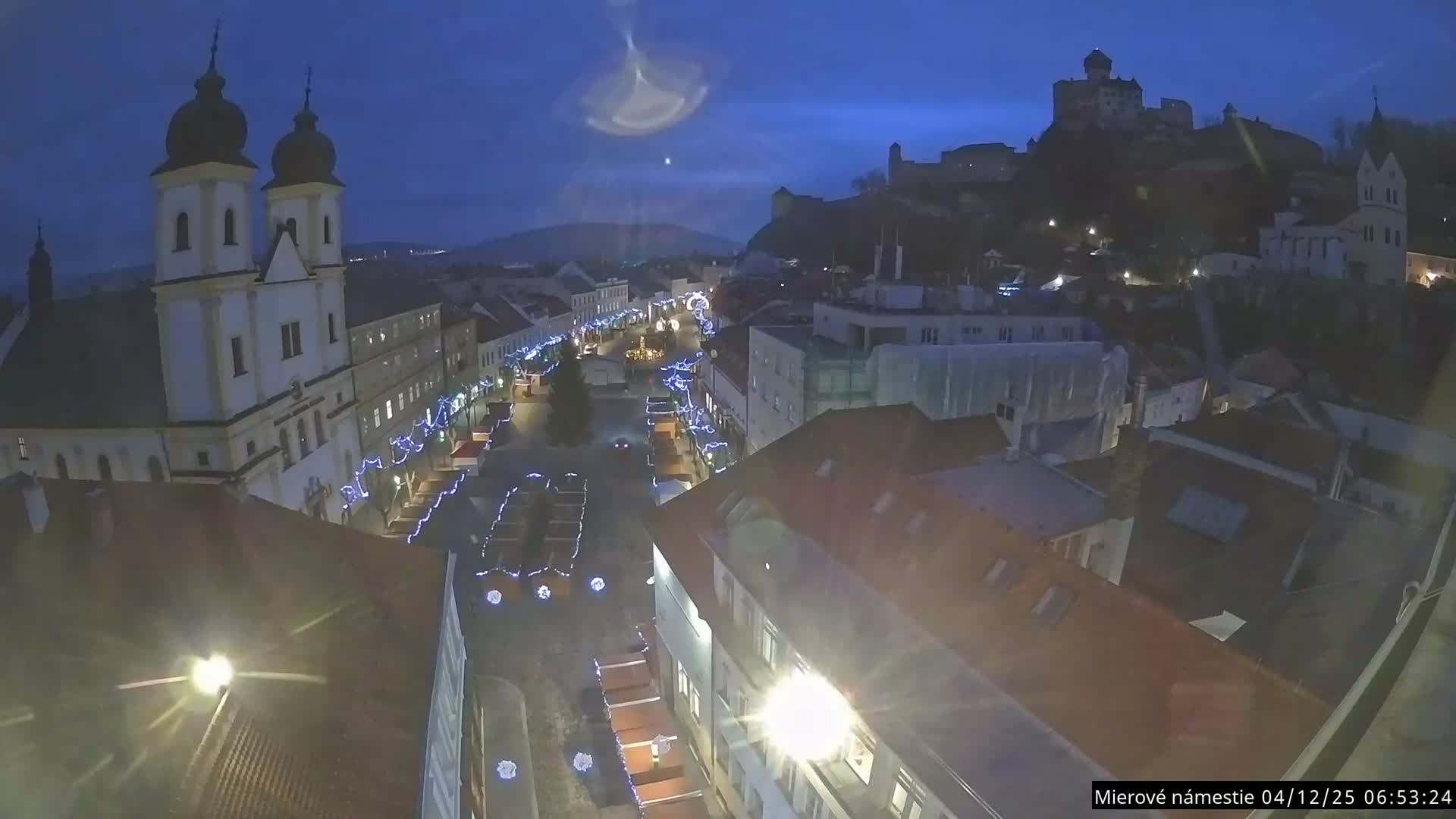 Trenčín, Piaristický kostol sv. Františka Xaverského Church & Trenciansky Hrad (Ttencin Castle) at Mierové námestie Square East View Live Cam - Trencin, Okres Trencin, Slovakia 