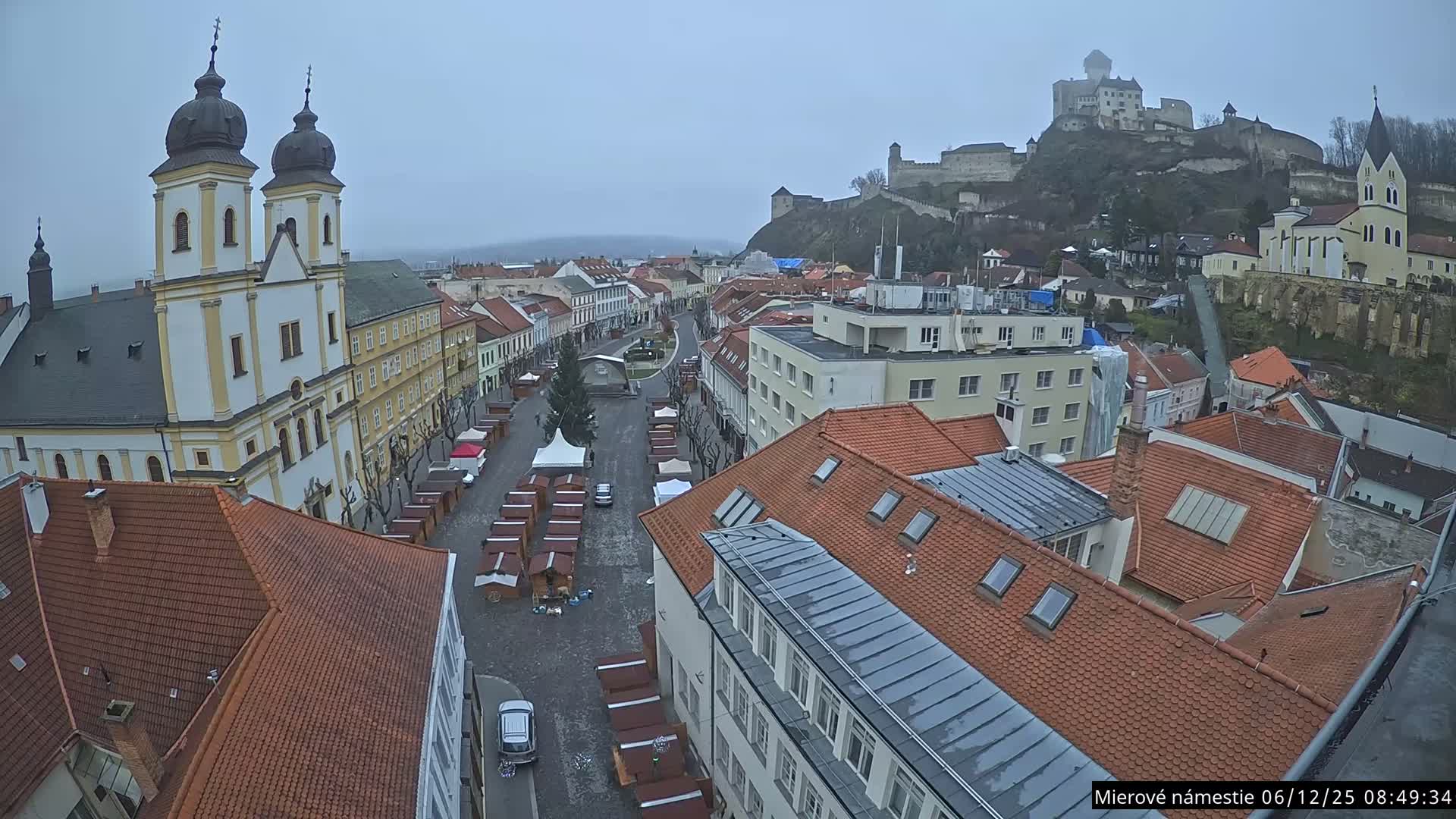 Trenčín, Piaristický kostol sv. Františka Xaverského Church & Trenciansky Hrad (Ttencin Castle) at Mierové námestie Square East View Live Cam - Trencin, Okres Trencin, Slovakia 