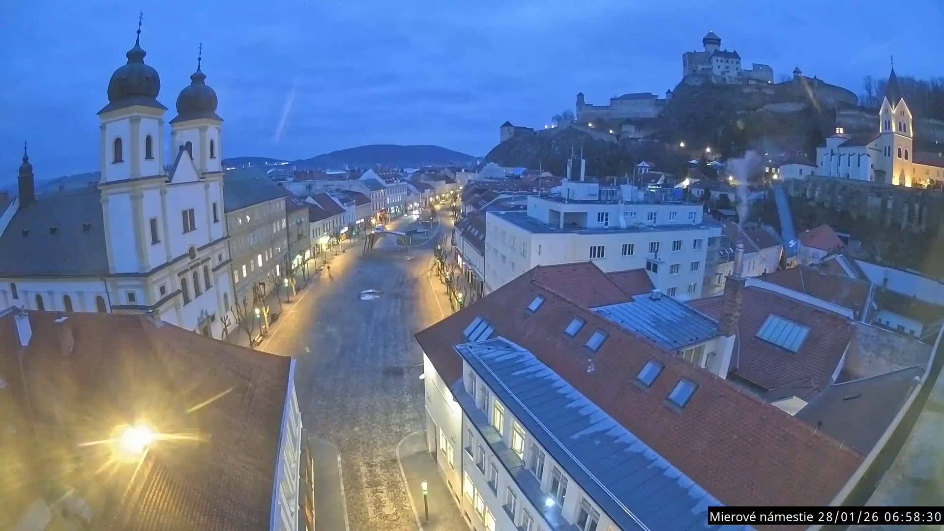Trenčín, Piaristický kostol sv. Františka Xaverského Church & Trenciansky Hrad (Ttencin Castle) at Mierové námestie Square East View Live Cam - Trencin, Okres Trencin, Slovakia 