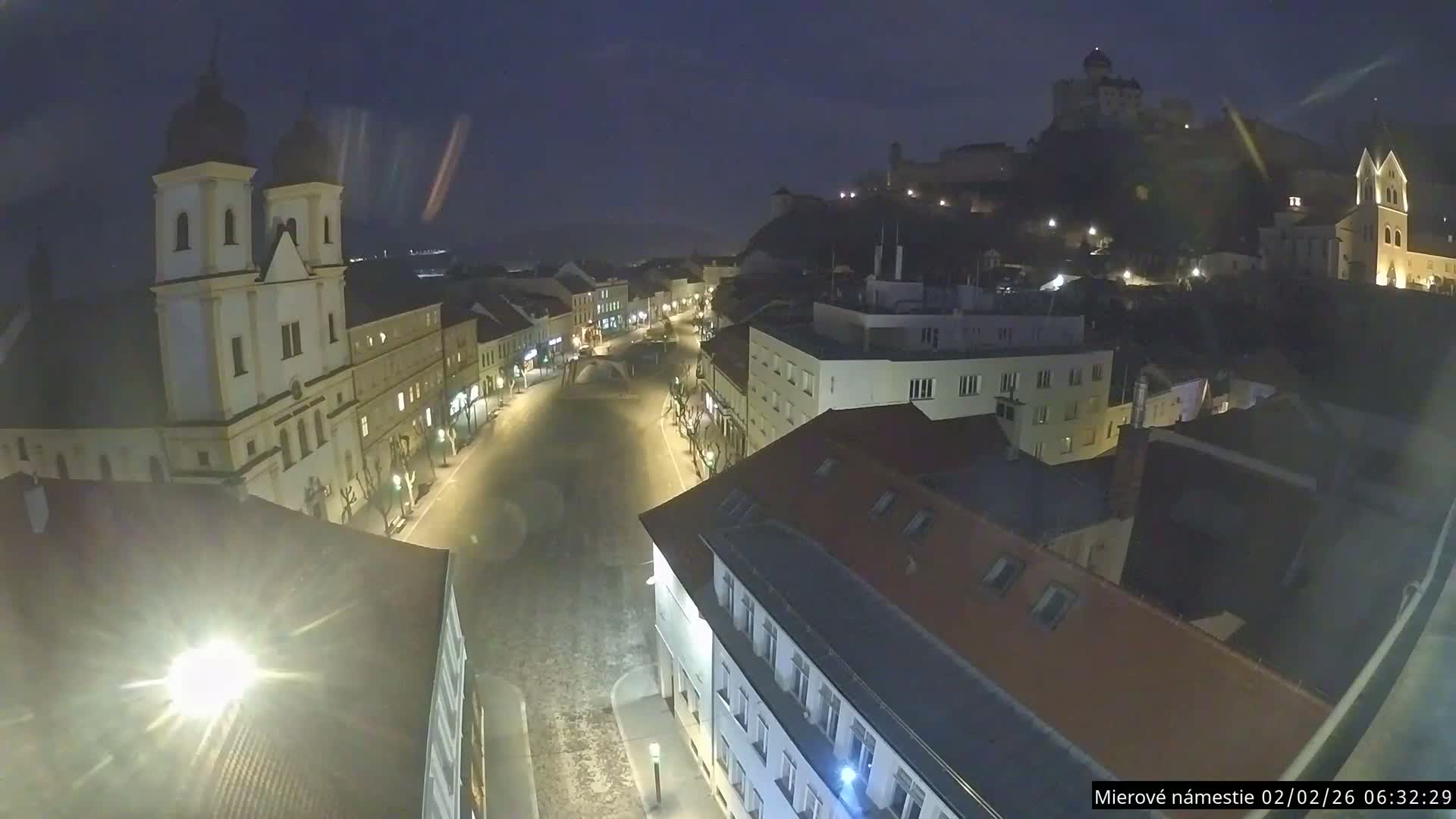 Trenčín, Piaristický kostol sv. Františka Xaverského Church & Trenciansky Hrad (Ttencin Castle) at Mierové námestie Square East View Live Cam - Trencin, Okres Trencin, Slovakia 