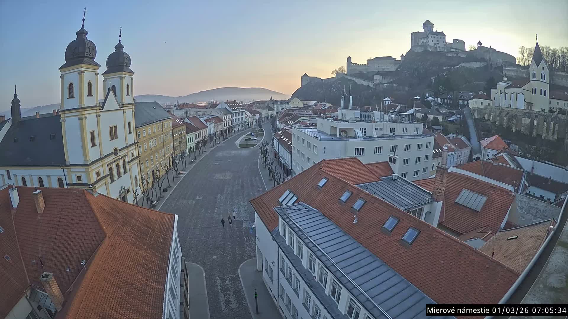 Trenčín, Piaristický kostol sv. Františka Xaverského Church & Trenciansky Hrad (Ttencin Castle) at Mierové námestie Square East View Live Cam - Trencin, Okres Trencin, Slovakia 