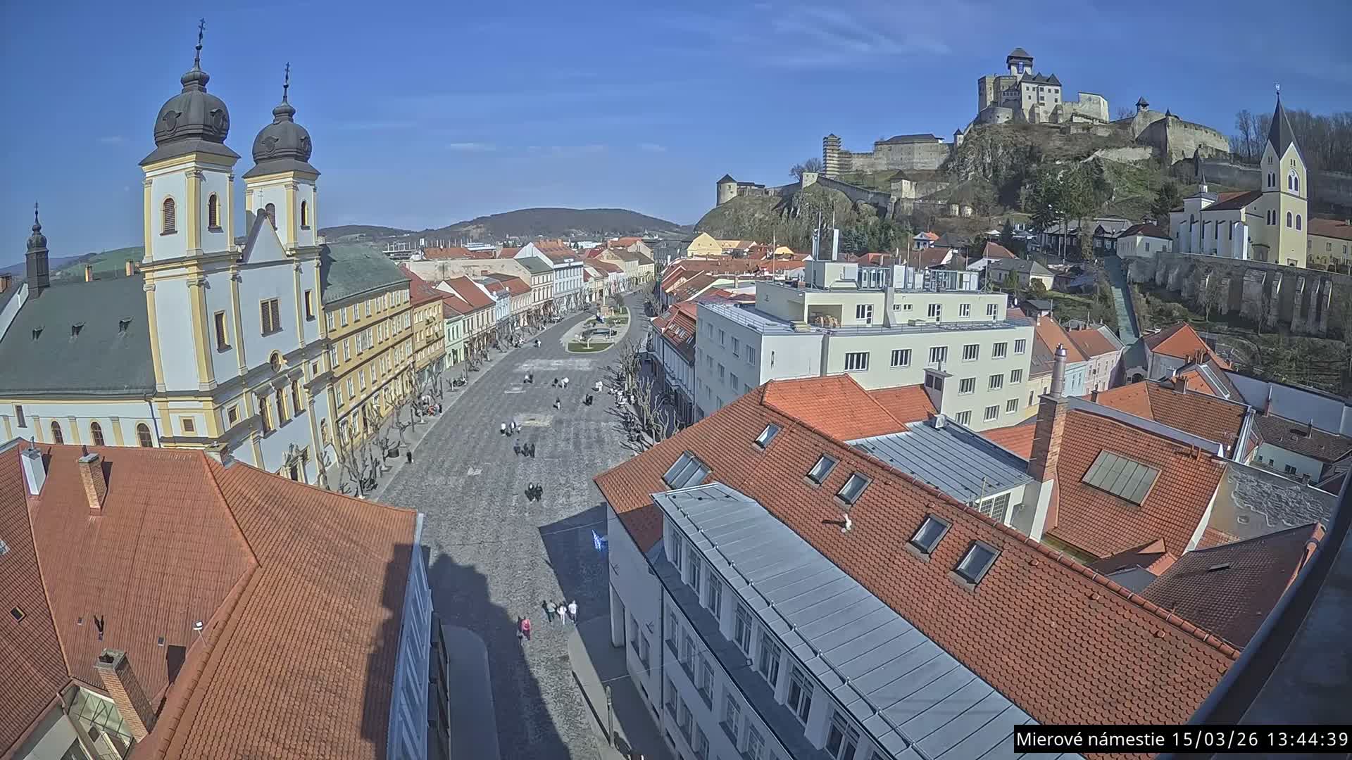 Trenčín, Piaristický kostol sv. Františka Xaverského Church & Trenciansky Hrad (Ttencin Castle) at Mierové námestie Square East View Live Cam - Trencin, Okres Trencin, Slovakia 
