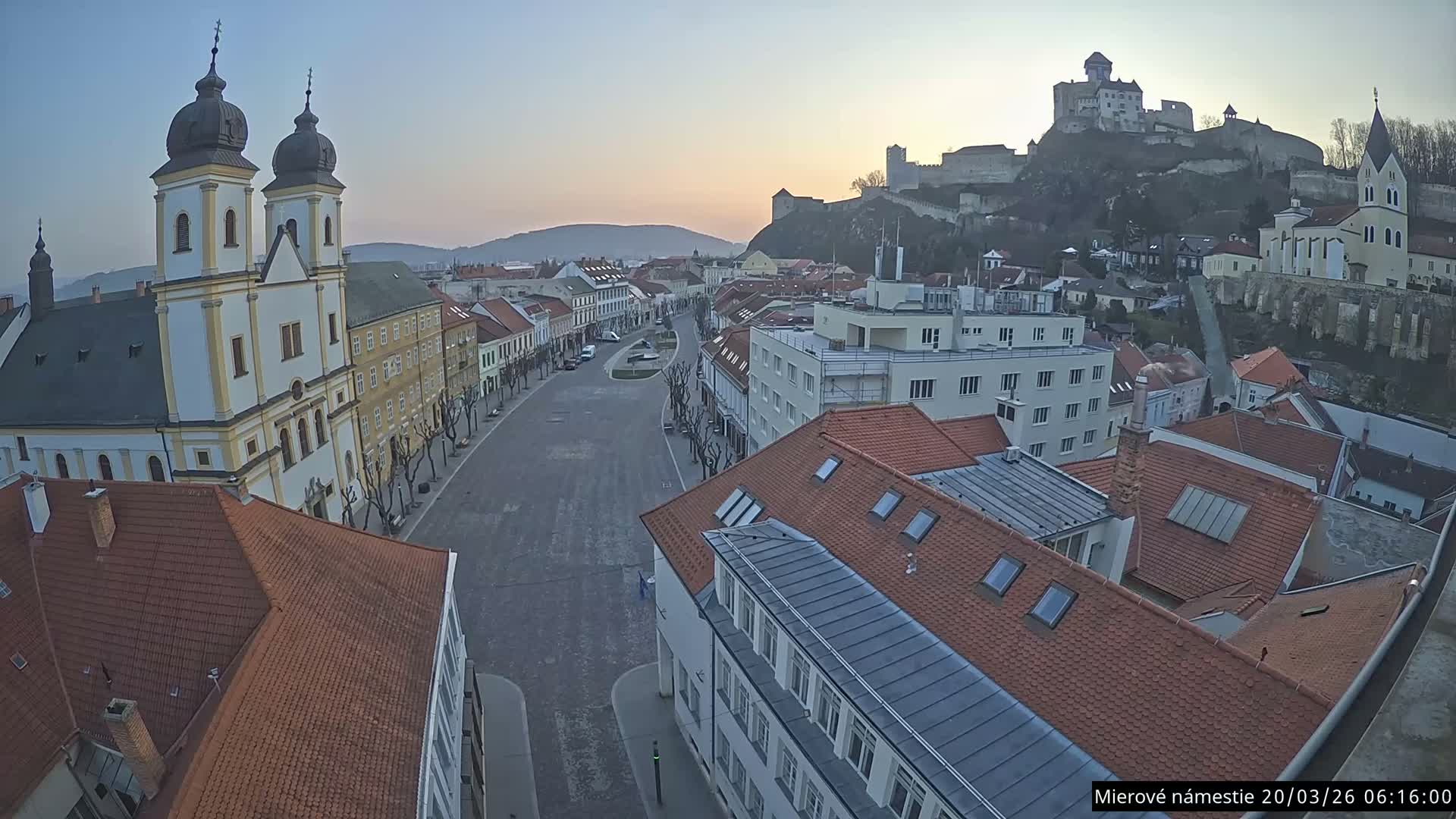 Trenčín, Piaristický kostol sv. Františka Xaverského Church & Trenciansky Hrad (Ttencin Castle) at Mierové námestie Square East View Live Cam - Trencin, Okres Trencin, Slovakia 