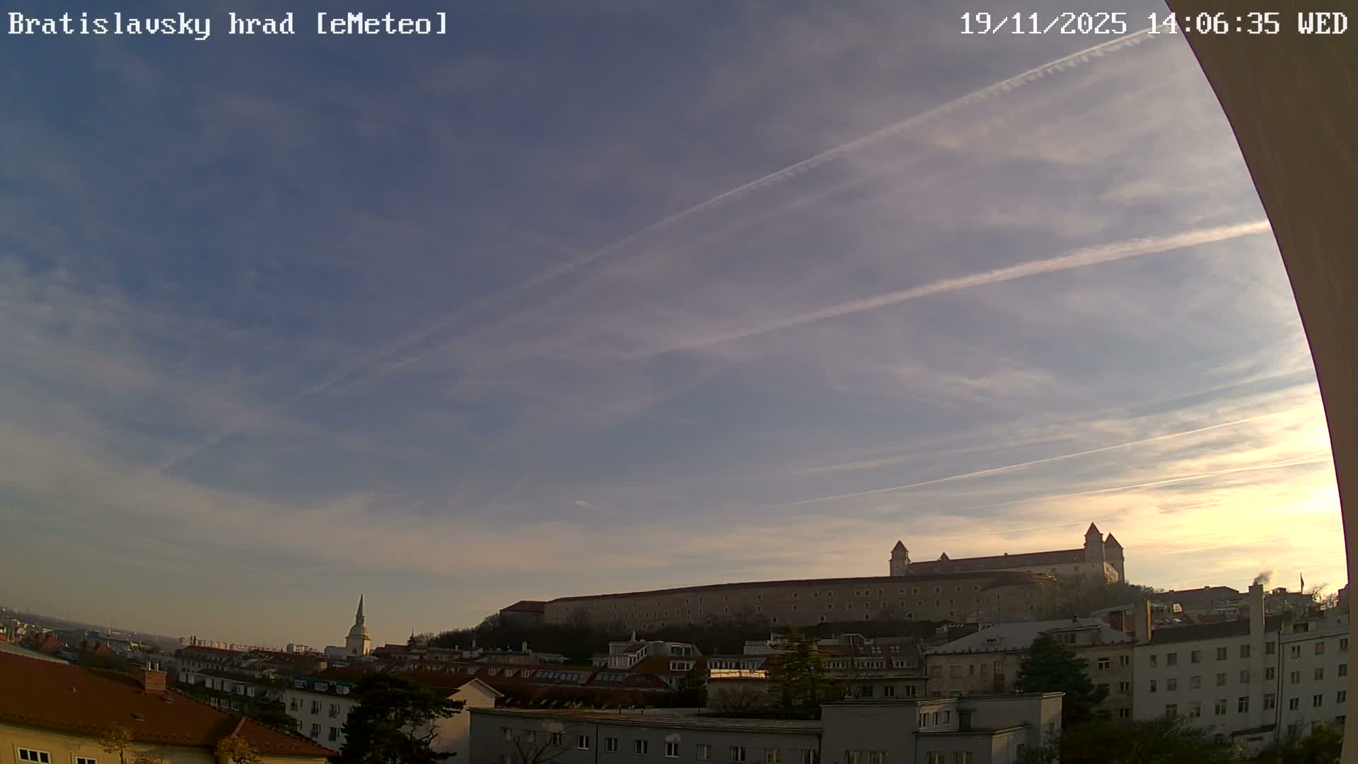 A nighttime, dark view shows dimly lit buildings and a dark sky.