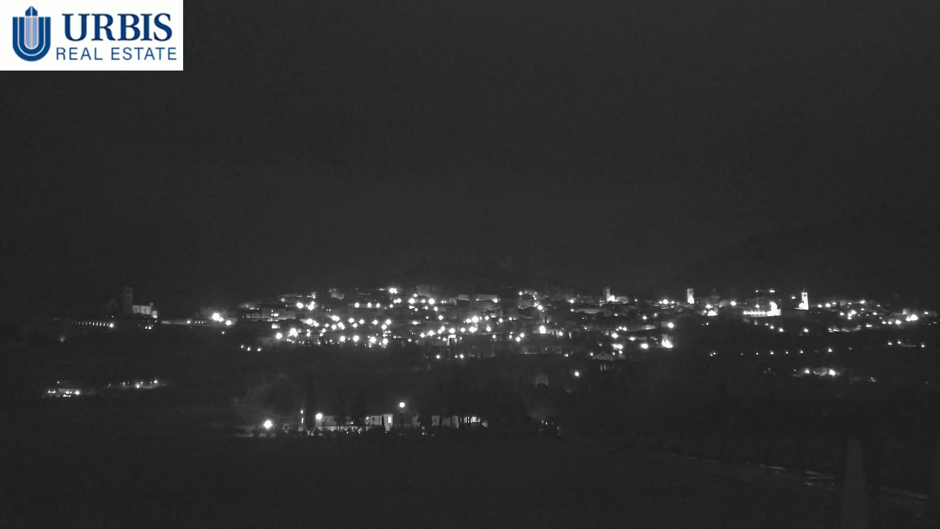 A nighttime, long-range view of a small town illuminated by scattered lights.
