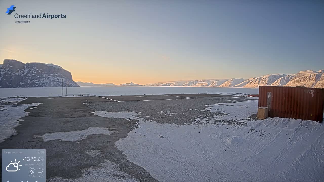 A clear, cold, snowy night reveals two yellow tanker trailers and a brown shipping container on a snow-covered field, with distant ice formations visible under a dark sky.