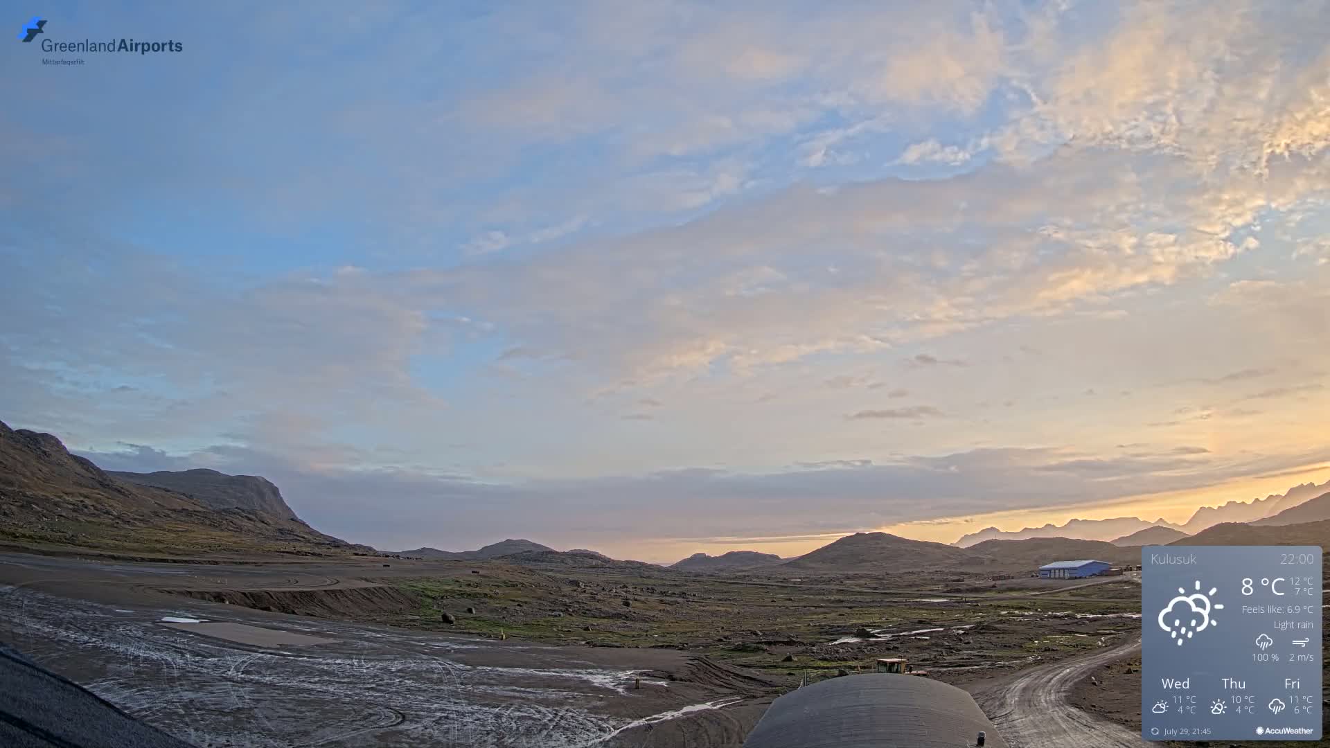A flat, barren landscape is shrouded in dense fog, with some construction equipment visible in the foreground.
