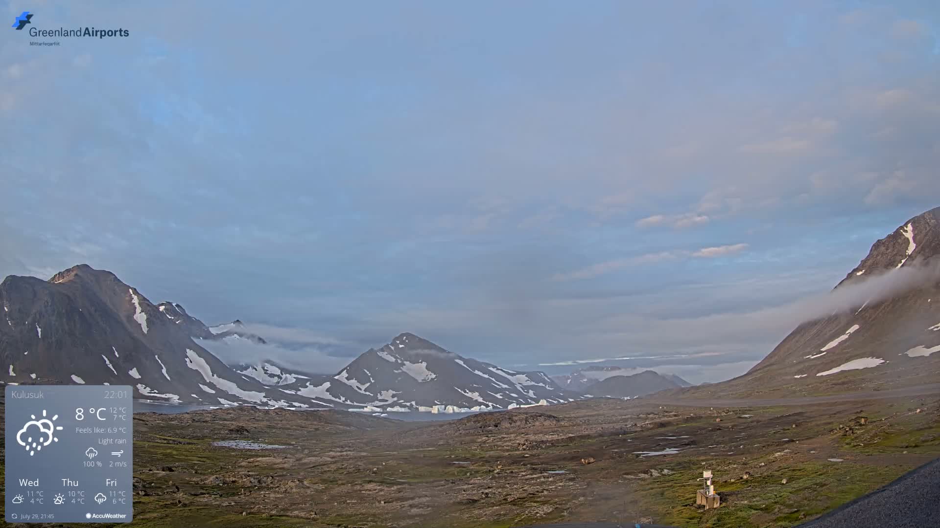 A flat, rocky landscape is shrouded in dense fog under a gray sky.