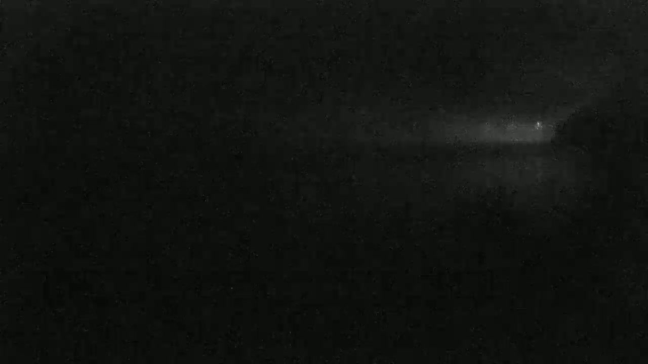 A dimly lit, foggy landscape is visible at night.