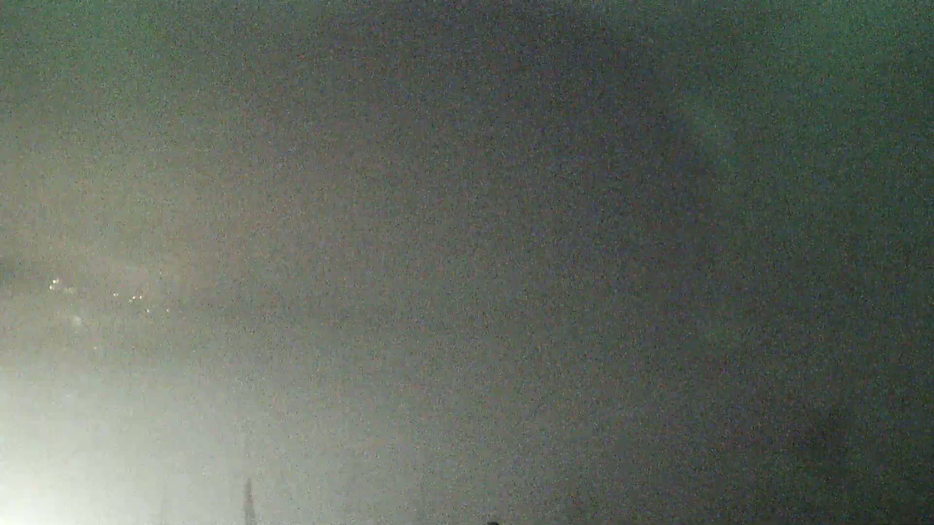 A hazy, dark sky shows a few distant, faint lights.