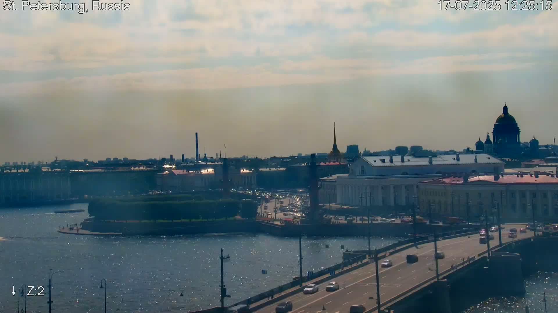 A hazy, sunny day overlooks a cityscape with a river and bridge, featuring prominent buildings and a dome.