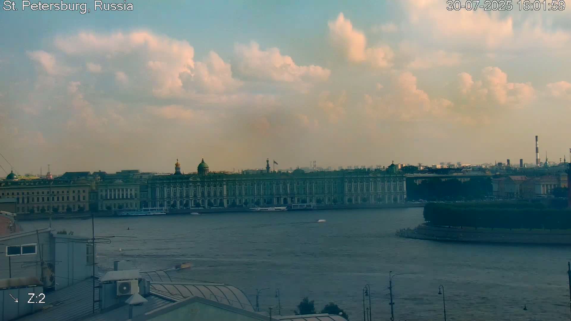 A hazy, sunny day overlooks a cityscape with a river and bridge, featuring prominent buildings and a dome.