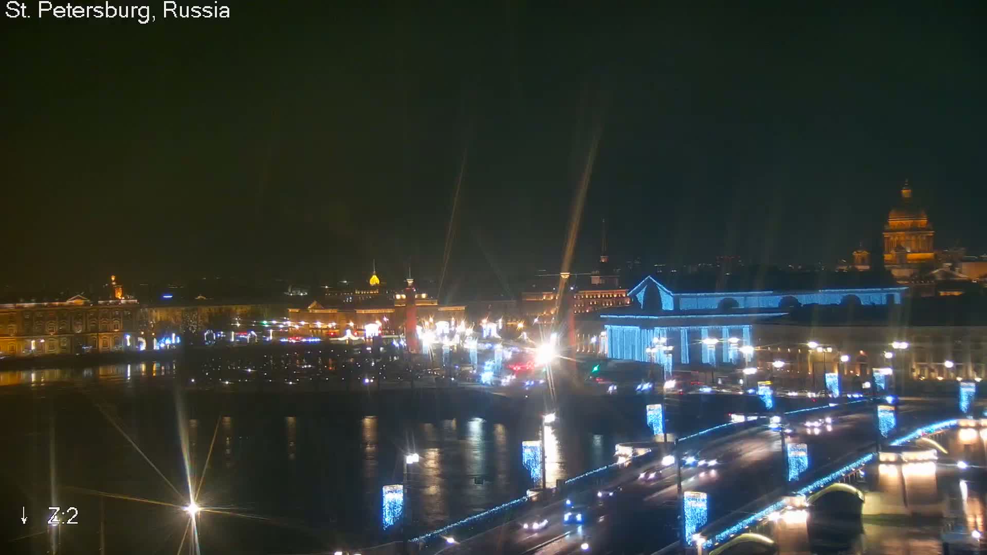 An overcast and hazy view of a city skyline features rooftops in the foreground, with a prominent golden-spired cathedral rising above other buildings in the midground, all under a dull grey sky.