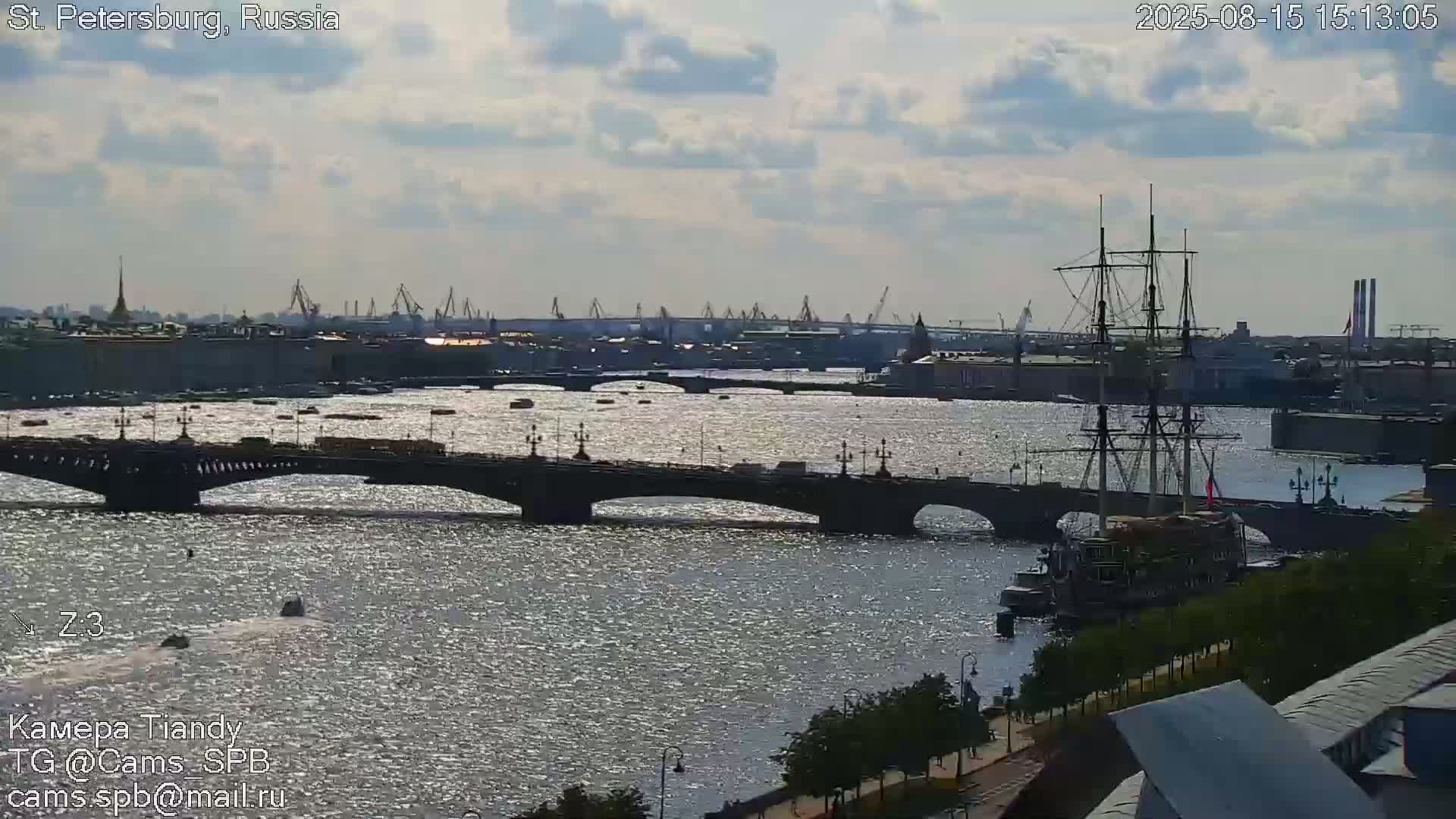 A blurry long shot shows a river with a bridge and a large ship, under a partly cloudy sky.