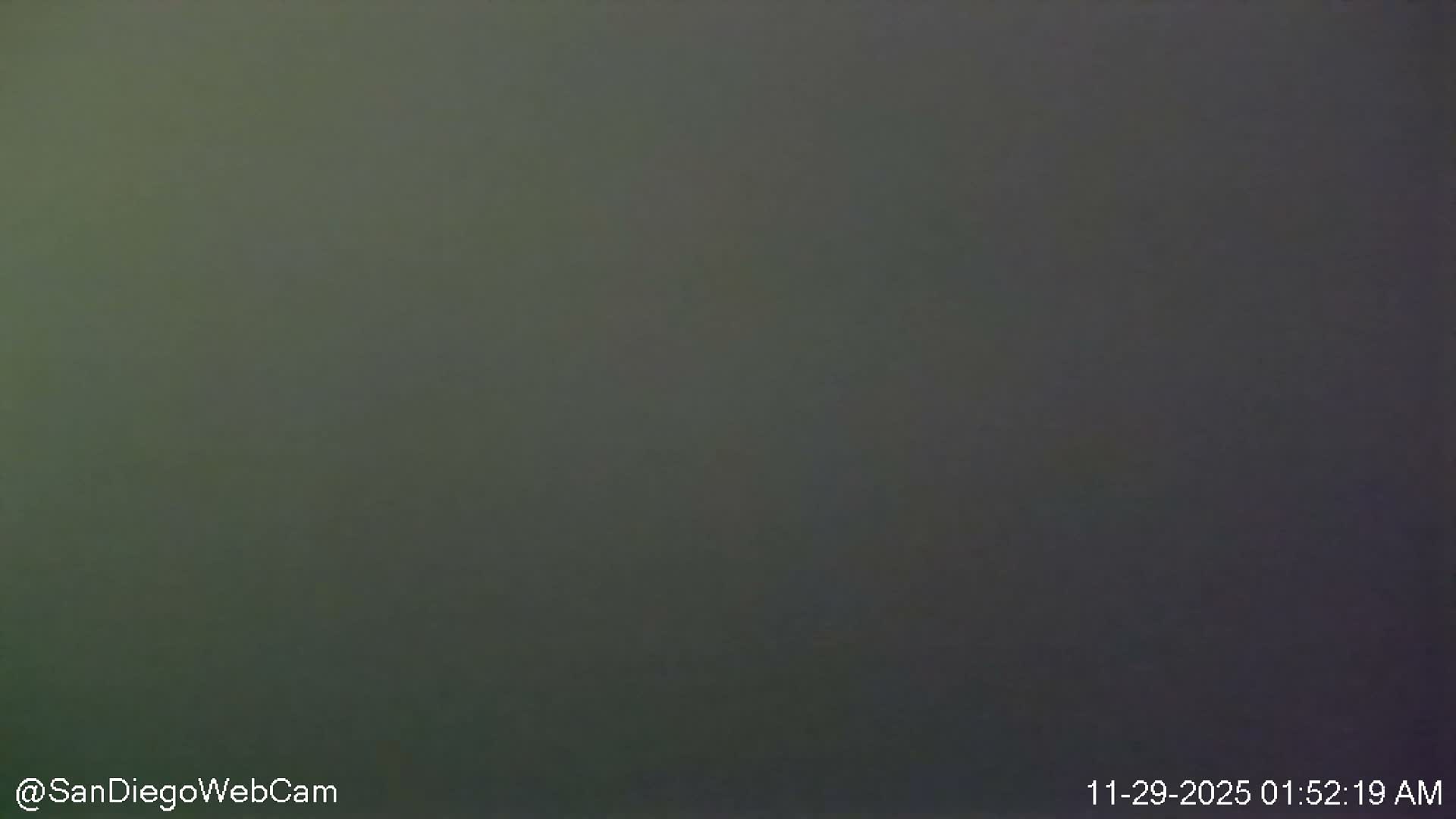 The image presents a uniformly dark grayish-green scene with no discernible features, indicating nighttime conditions.