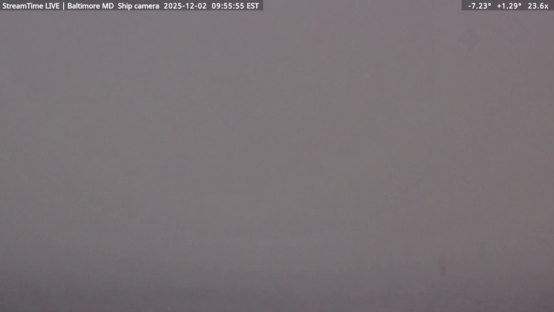 The image depicts a scene entirely obscured by extremely dense fog or mist, rendering the view as a uniform field of gray.