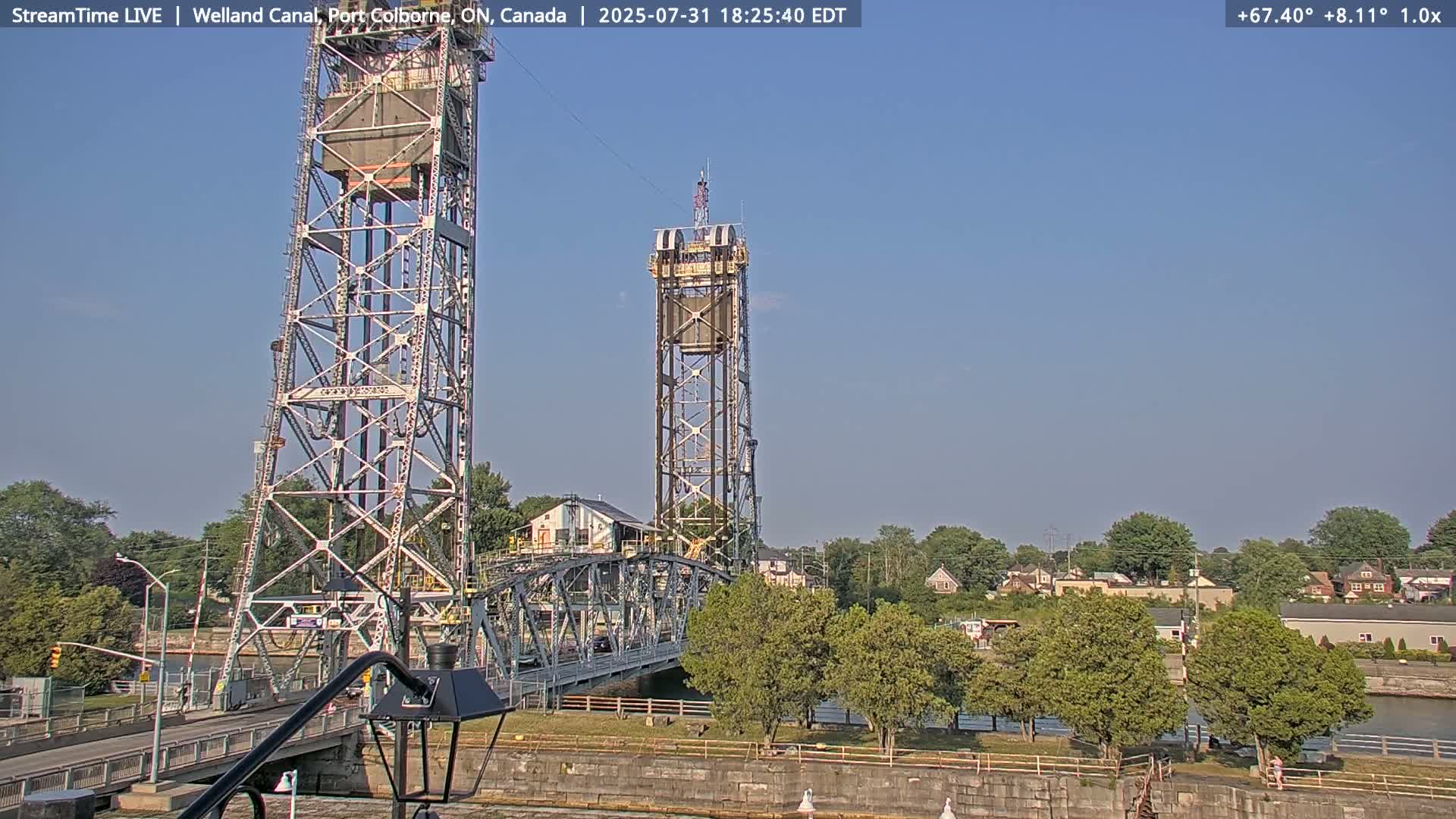 A metal lift bridge with two tall towers stands over a waterway under a clear blue sky.