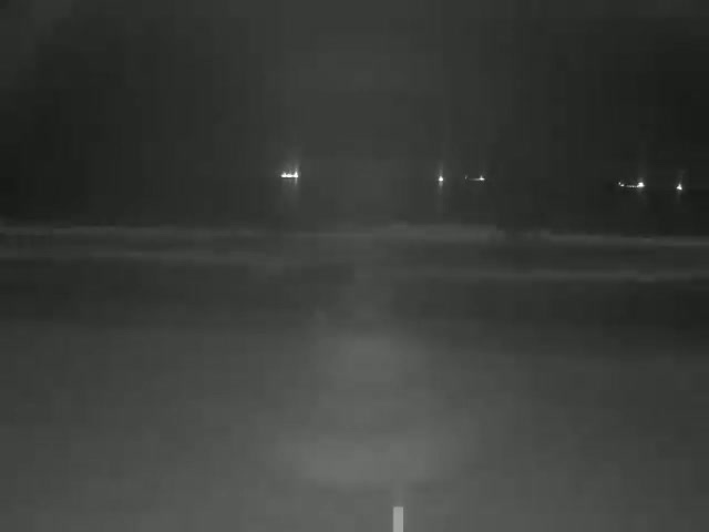 A blurry, nighttime image shows distant lights through heavy rain or fog.