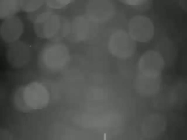 A blurry out-of-focus image shows a dark gray background with indistinct shapes resembling out-of-focus lights.