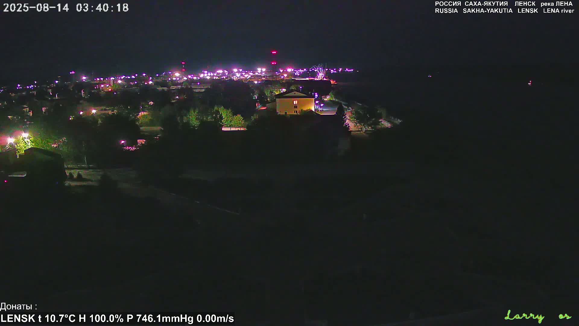 A nighttime, high-angle view of a town with scattered lights, under clear skies.