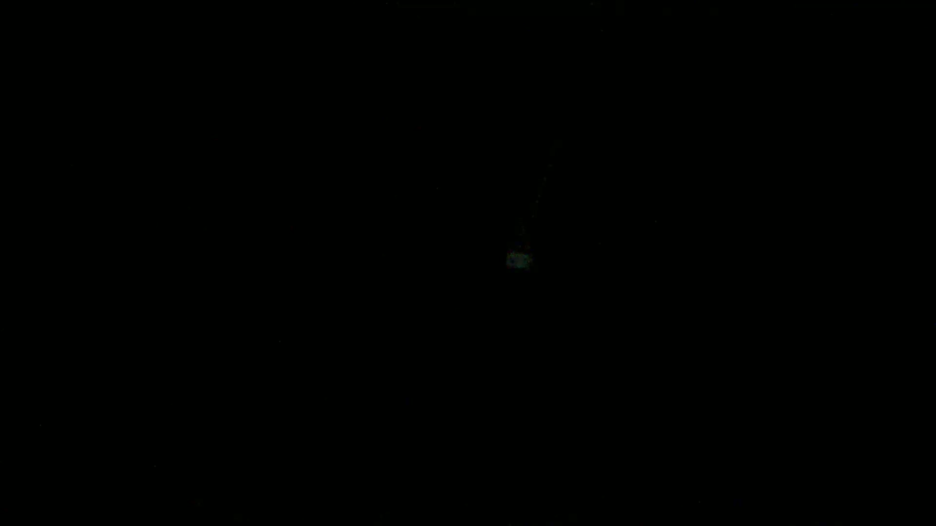 The image is almost entirely black, with a small, faint, light-colored speck near the center.