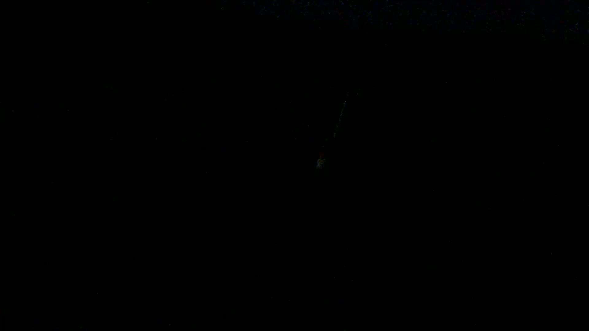 A faint, vertical streak of light is visible against an otherwise completely dark background.