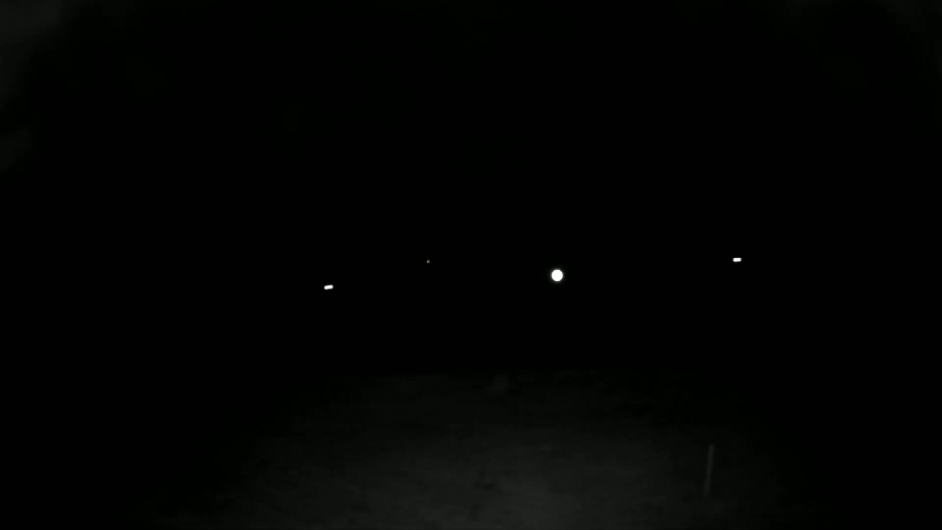 Several small, distant lights are visible in the dark, possibly at night.