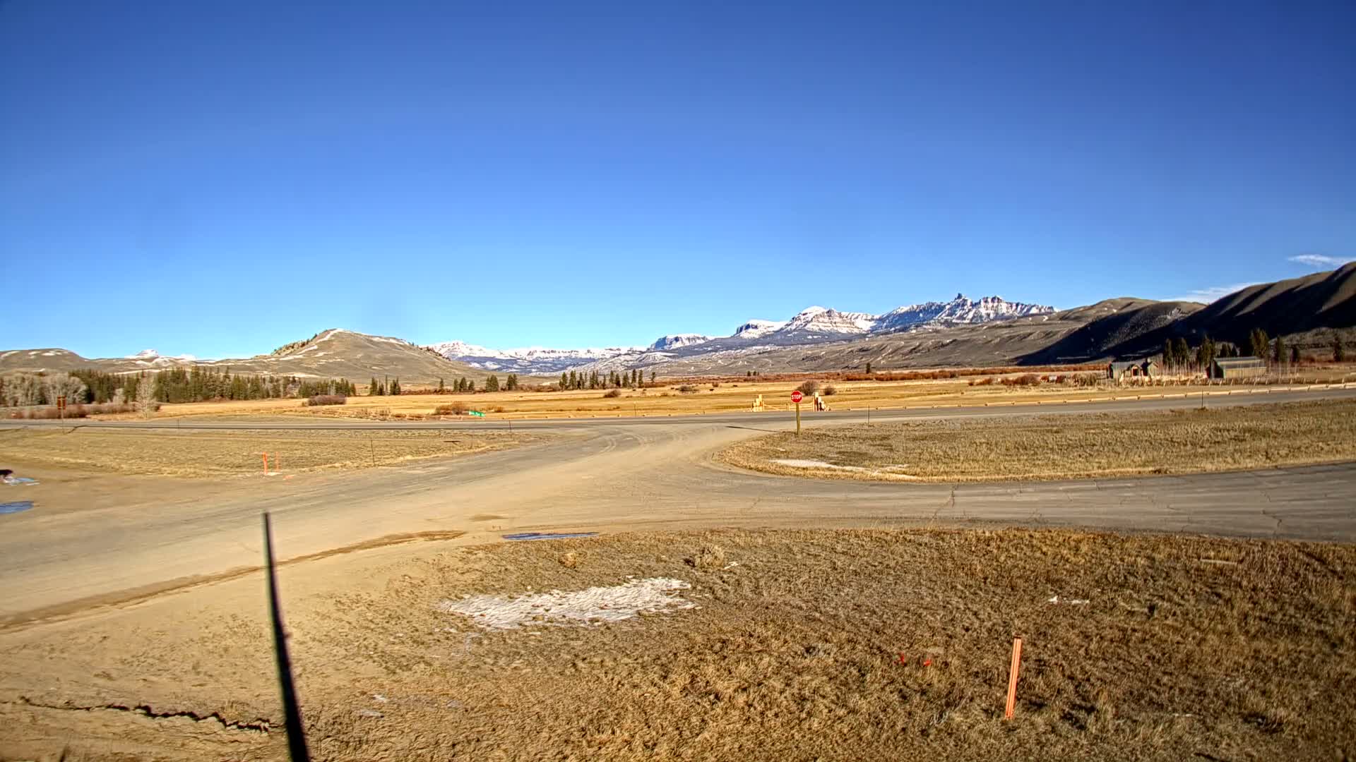 The image depicts a dark, nighttime outdoor scene with heavy snow falling, illuminated as numerous white streaks and dots, and a few faint distant lights visible on the right.