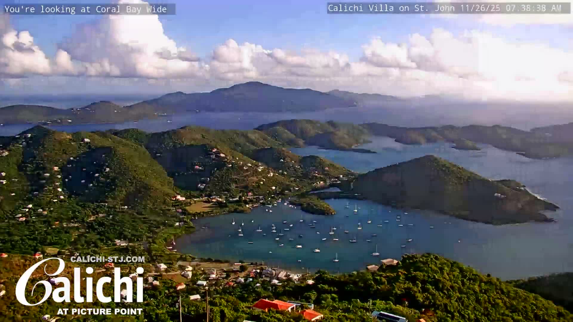 The image captures a wide view of a coastal settlement at night, with numerous artificial lights illuminating the landscape under clear skies.