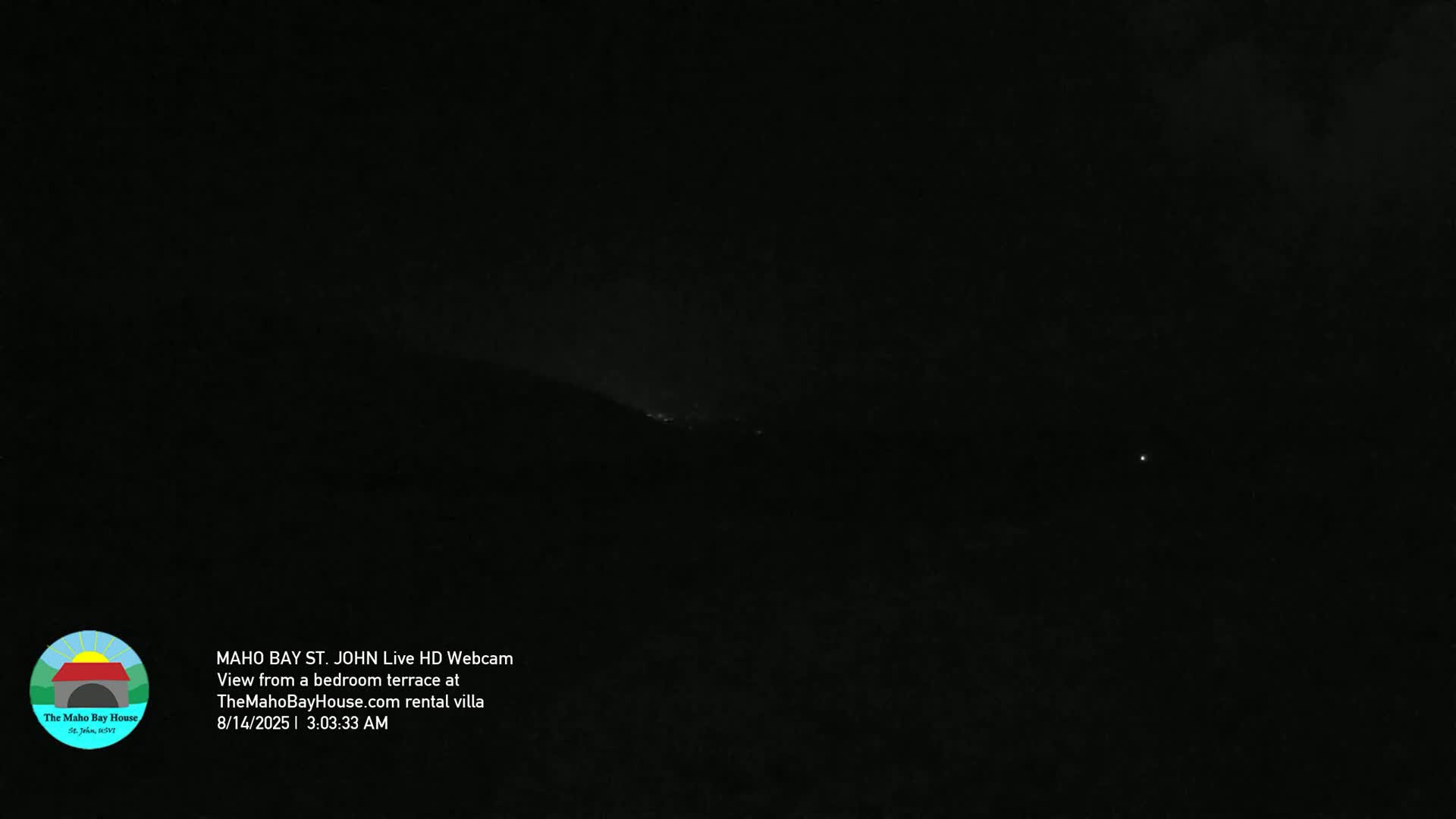 A dark nighttime scene shows a distant, dimly lit hillside.
