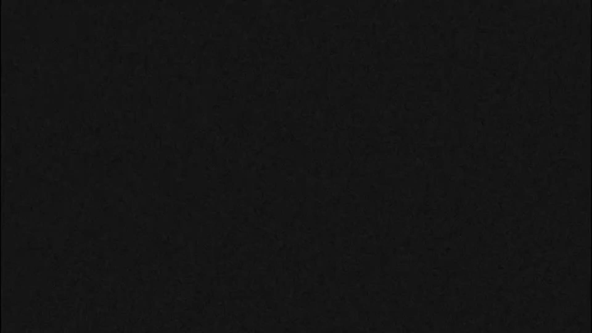 The image displays a uniform field of very dark grey or black with a subtle, textured grain.