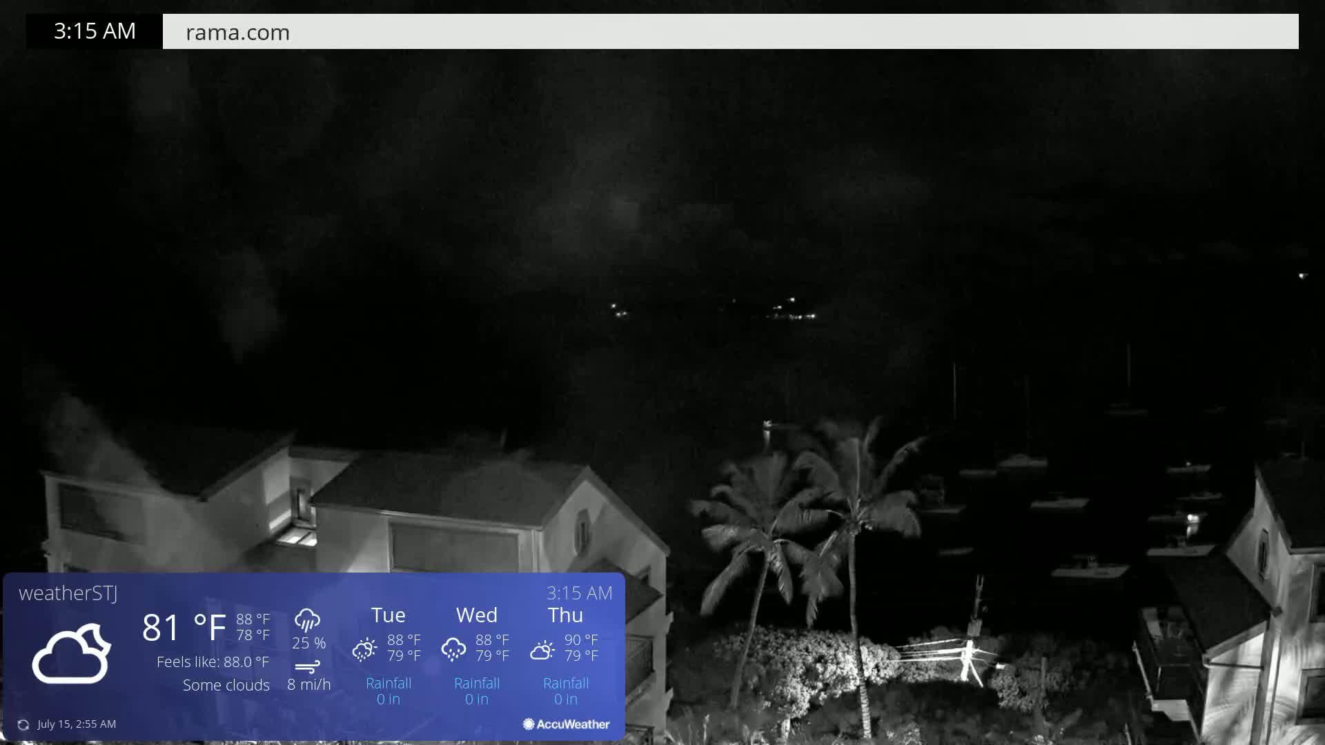 A nighttime view of a waterfront area with some clouds, showing buildings, palm trees, and boats in the water.