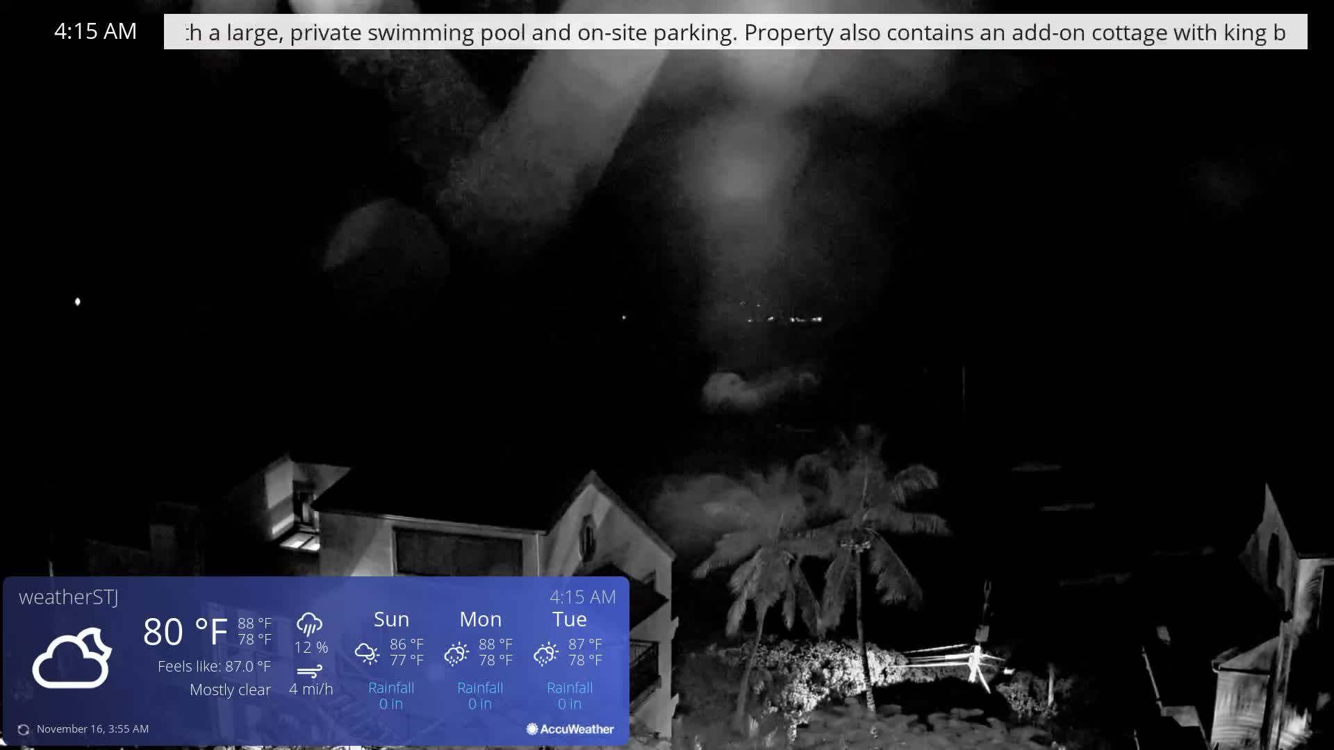 The image depicts a mostly clear, dark night in a tropical or coastal setting, featuring illuminated buildings, palm trees, and distant lights.