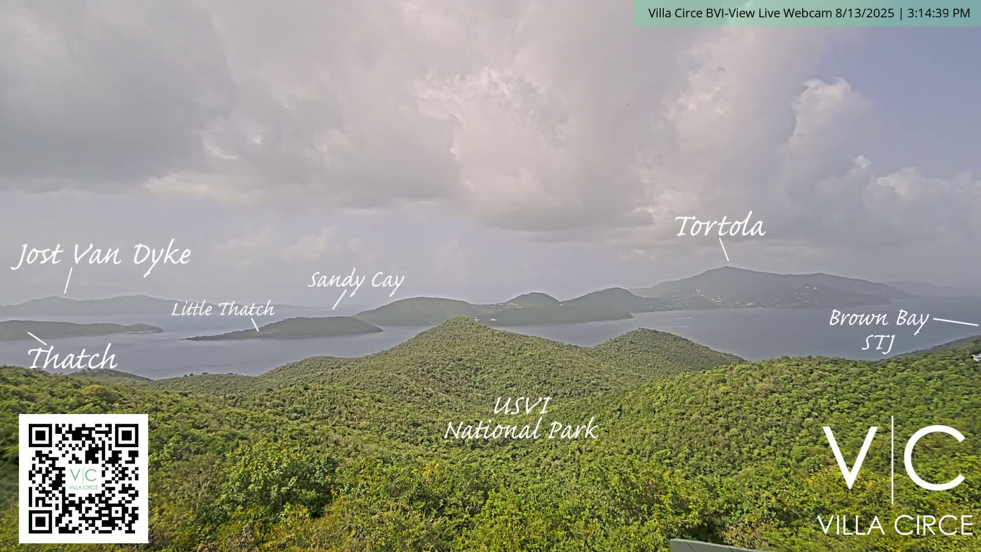 A panoramic view of lush green islands and calm blue waters under a cloudy sky.
