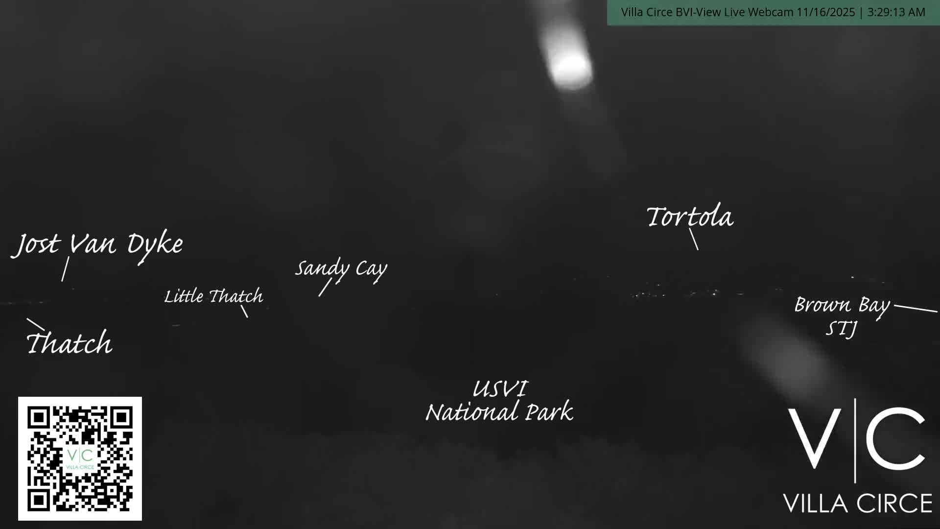 The image presents a very dark and indistinct outdoor nighttime scene, featuring faint horizontal lines of distant lights and several prominent, blurry white light sources.