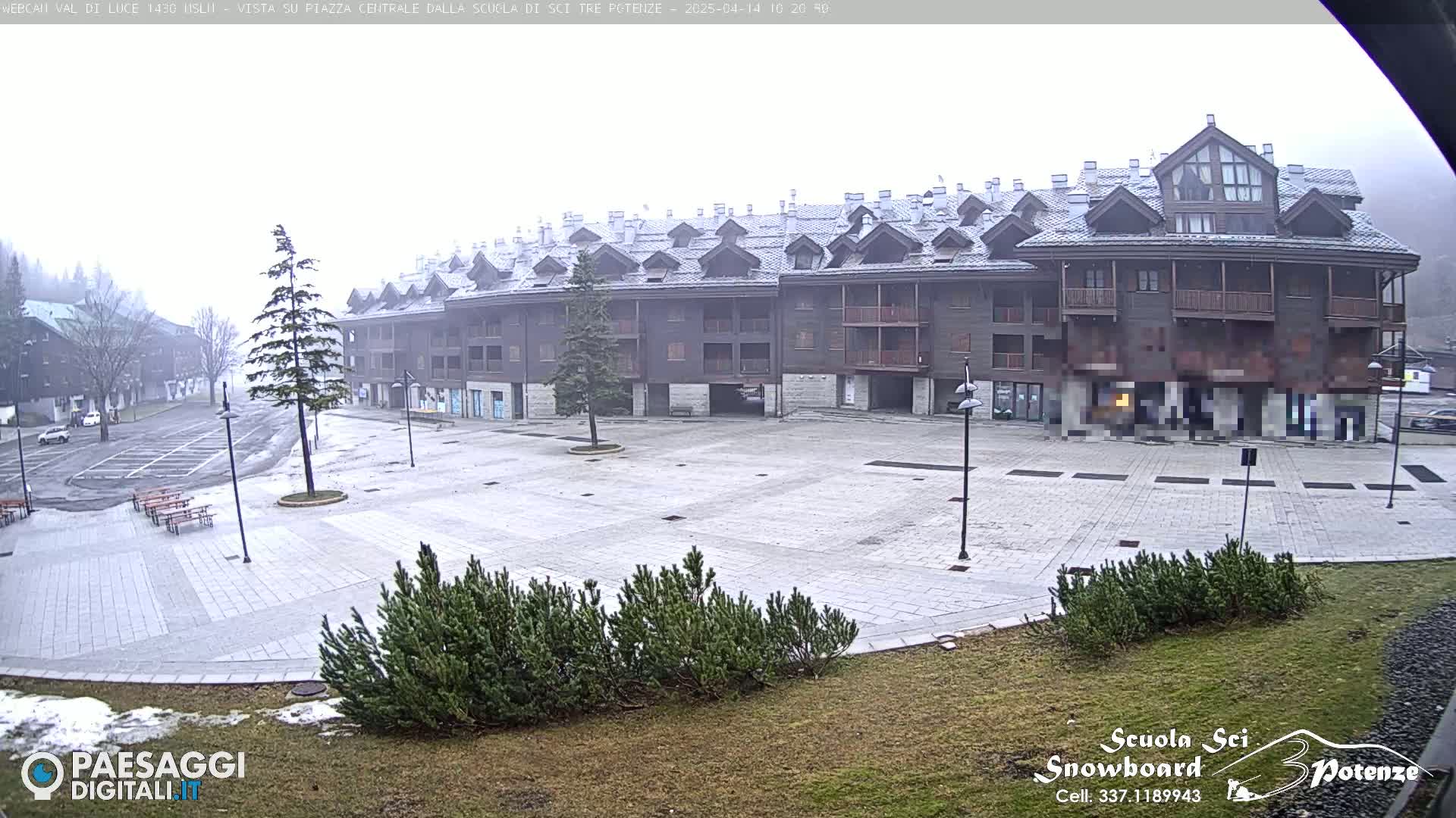 A snow-dusted plaza with a large multi-story building is visible in foggy conditions.
