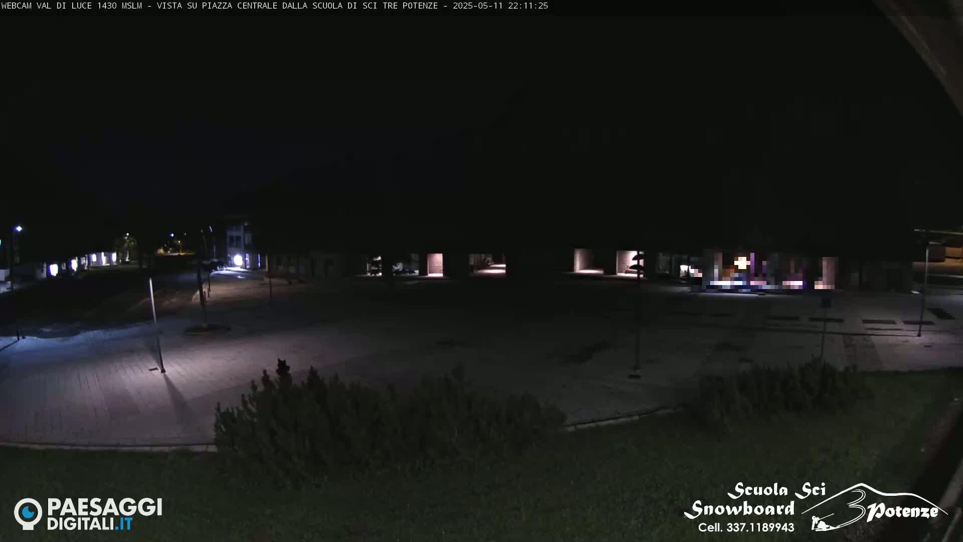 An empty, paved plaza is dimly lit at night.