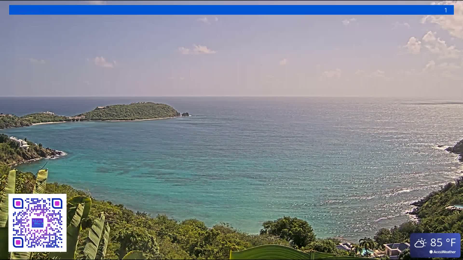 A cloudy night scene overlooks a bay with several distant landmasses and faint lights on the water, showing tropical foliage in the foreground, with a temperature of 78°F.